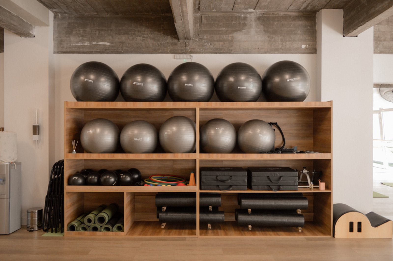 Estantería de madera con pelotas de ejercicio en sala de fitness — proyecto Estudio Integral SC - Tandil, por Estudio Agustina Satostegui, en Tandil