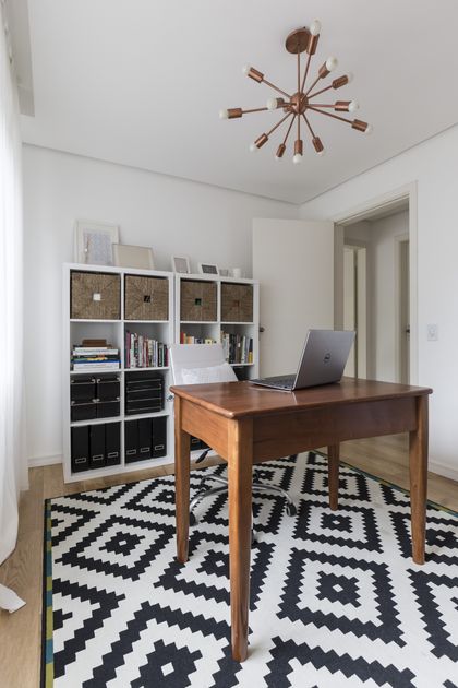 Oficina moderna con escritorio madera, estantería blanca y piso geométrico — proyecto Apartamento 201, por Camila Cavalheiro Arquiteta