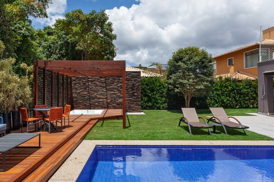 Patio moderno con pileta, deck de madera y pérgola estructura — proyecto CASA JL, por Frederico Bicalho Arquitetura