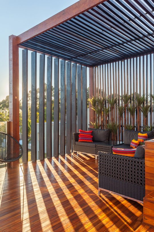 Terraza moderna con pergola, deck de madera y muebles negros — proyecto CASA RR, por Frederico Bicalho Arquitetura