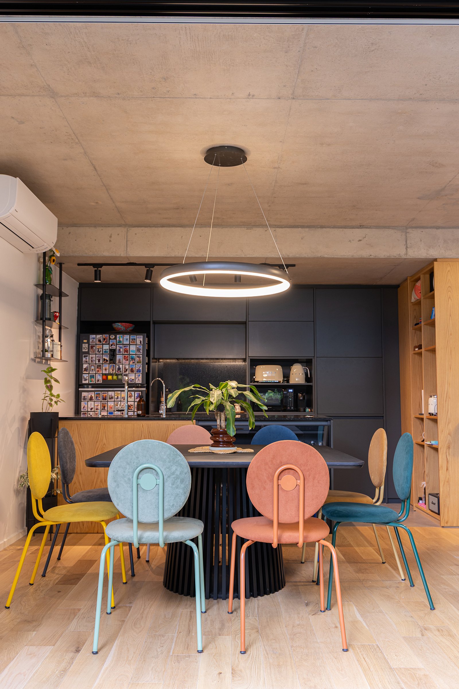 Comedor moderno con sillas de colores y lámpara circular sobre mesa negra — proyecto THE PINK - ARQ MDBK, por Gaby Alfonso, en Palermo Soho