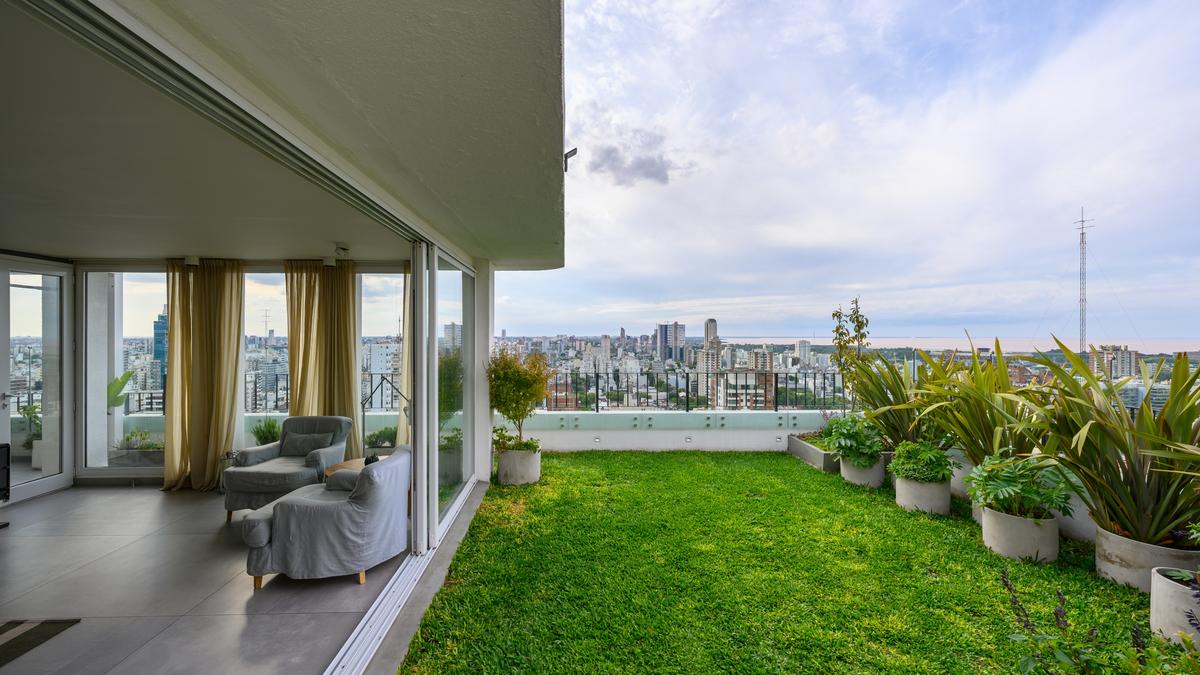 Varanda de apartamento com vista urbana e jardim — projeto ECHEVERRÍA, por Siuk Studio, em CABA