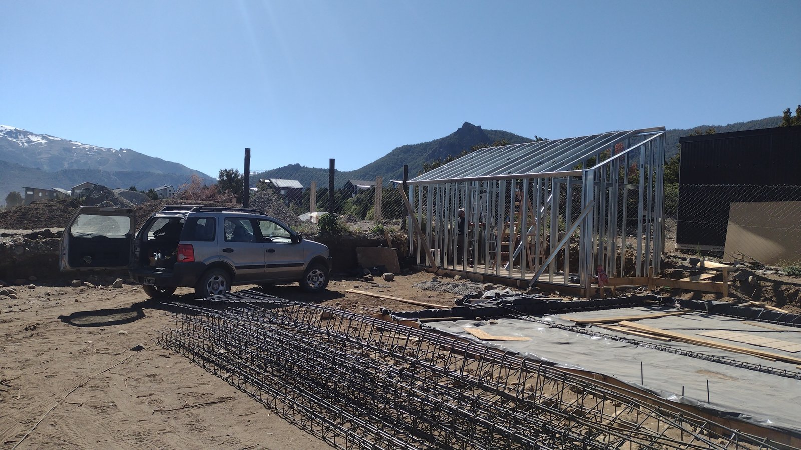 estructura metálica de casa en construcción con montañas — proyecto Depósito y taller en lomas de cauquen, por LP reformas y refacciones , en San Carlos de Bariloche