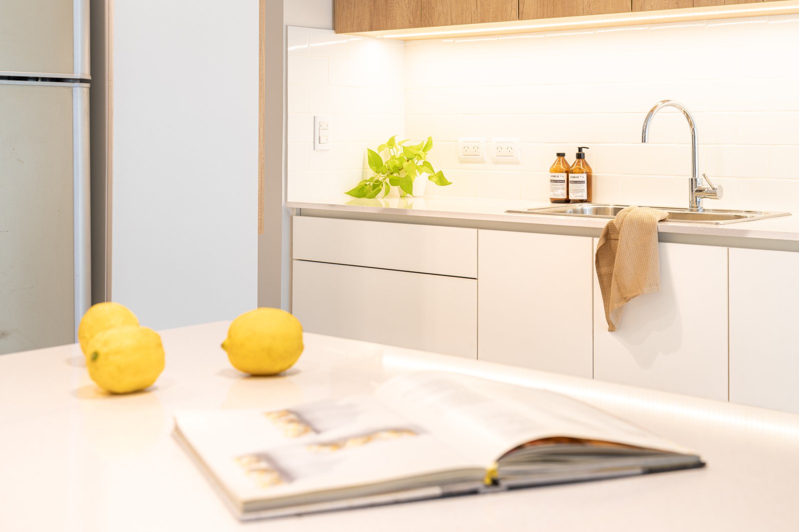 Cocina moderna blanca con isla y encimera de mármol — proyecto SANTA FE, por Maria Menna Arquitecta, en Mar del Plata