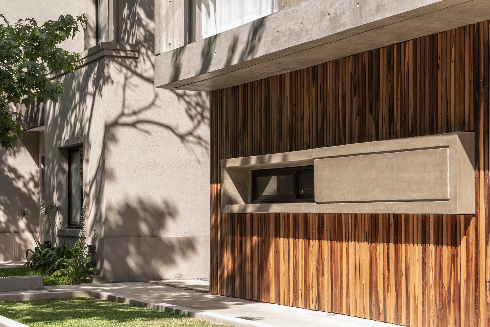 Fachada moderna con detalles en madera y hormigón — proyecto Casa Emilia, por Grupo CRBN, en Parque Leloir