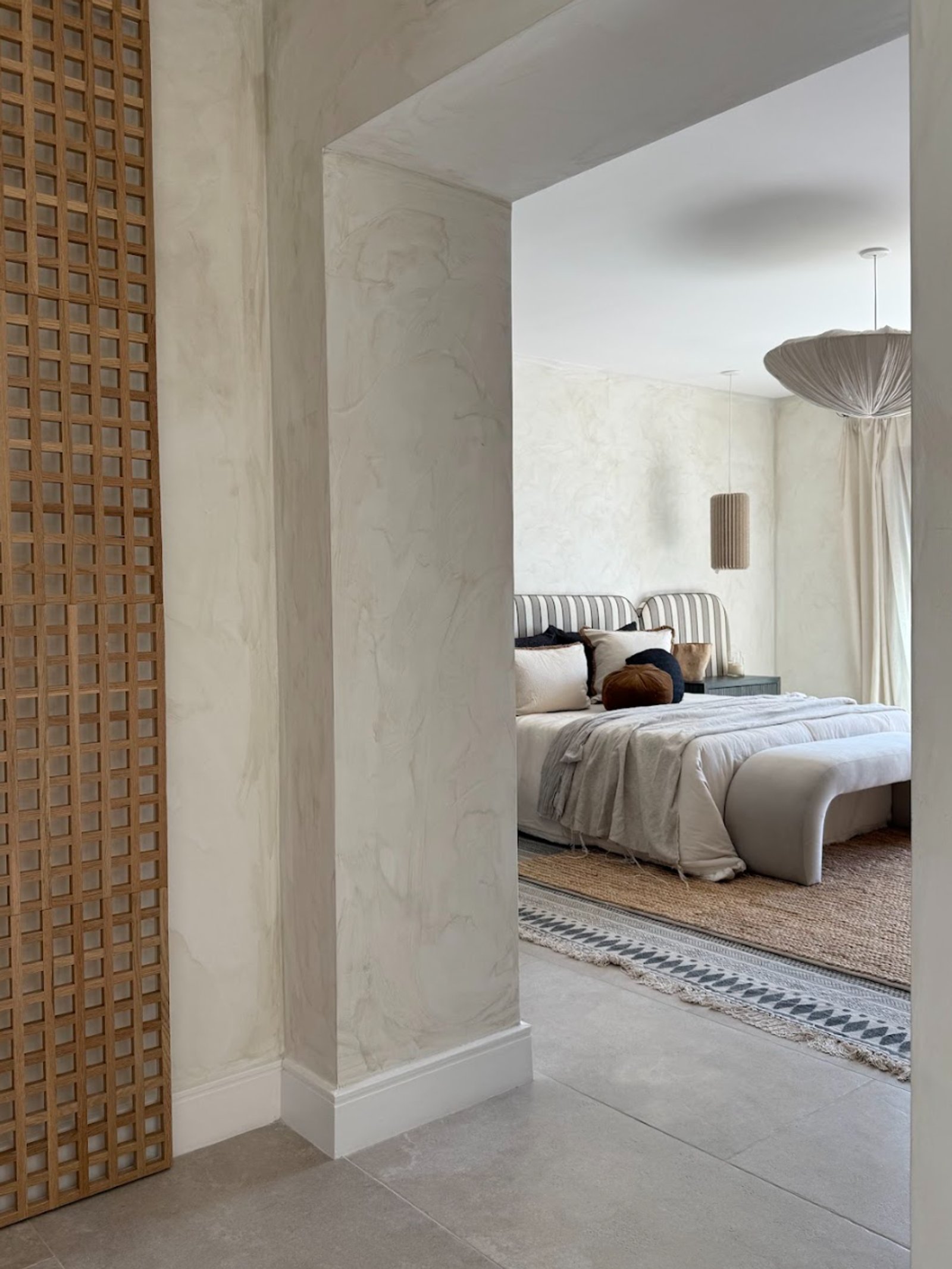 Dormitorio moderno con paredes texturizadas y luz colgante grande — proyecto La Verbena, por Grupo Pauta Arquitectura, en Alejandro Korn 3150