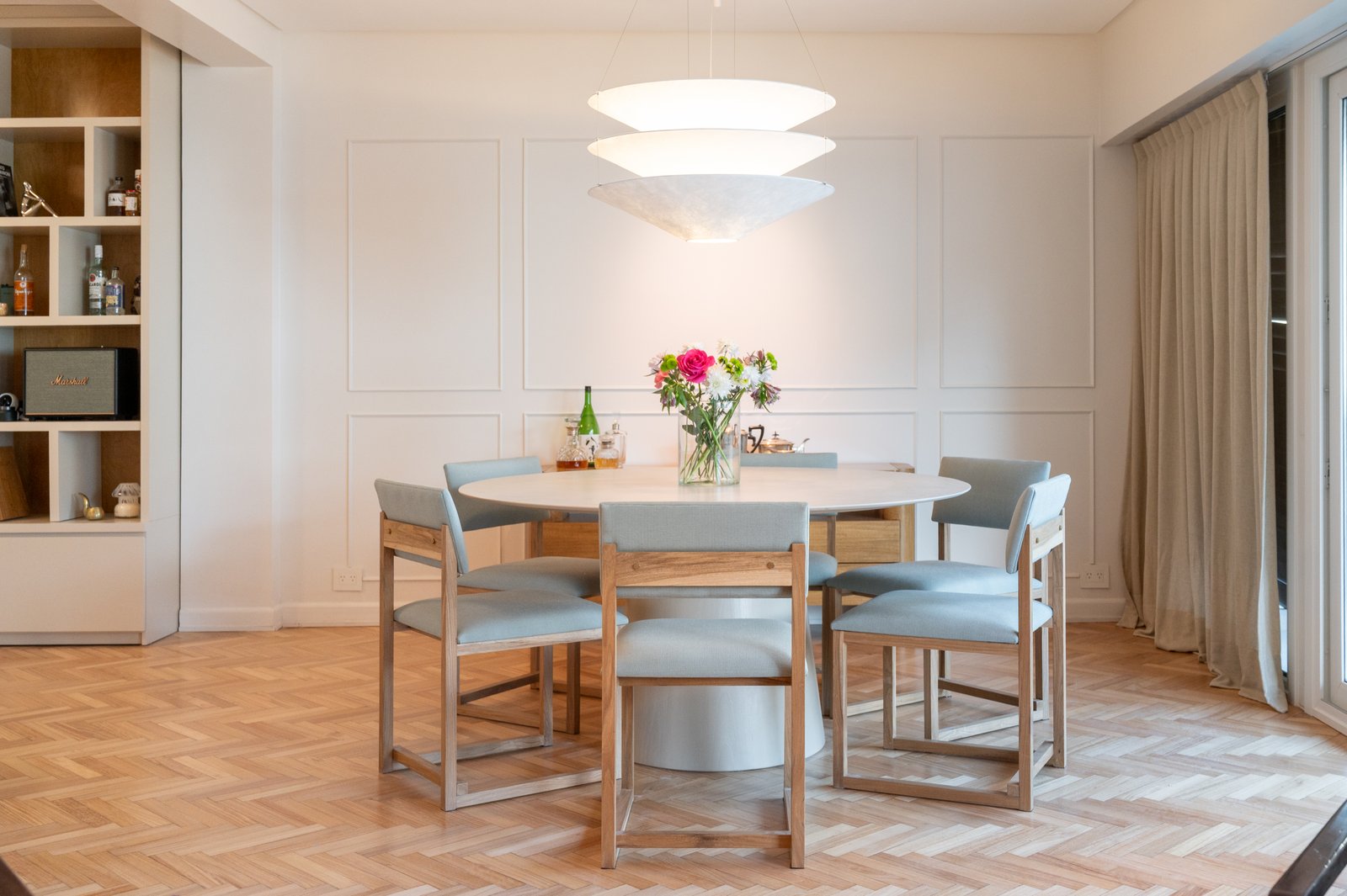 Sala de jantar moderna com cadeiras azul-claras e mesa redonda — projeto ALVEAR TYM, por AB ARQUITECTURA, em Recoleta