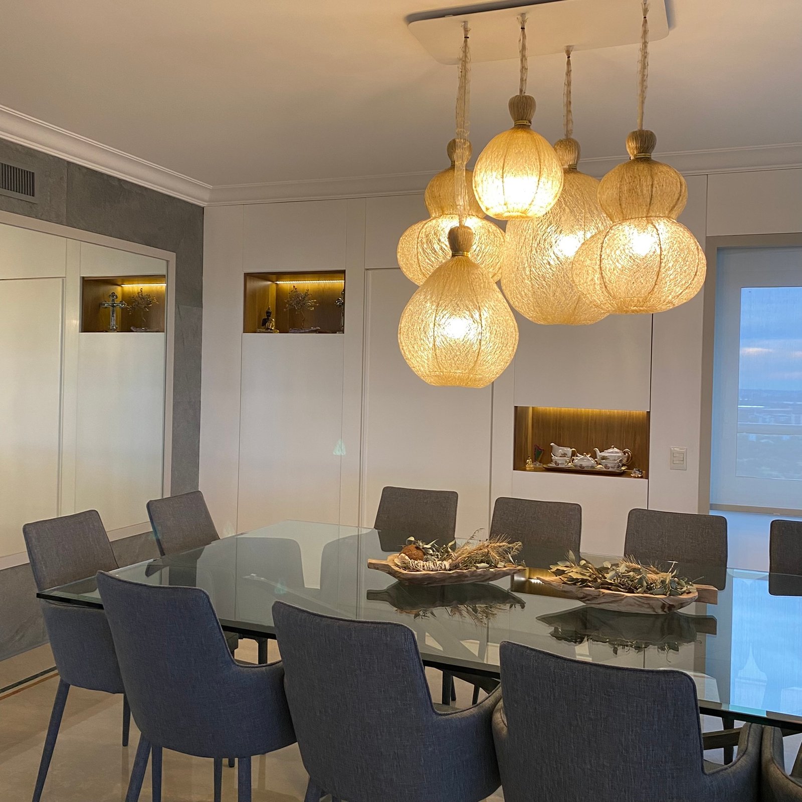 Sala de jantar moderna com luminárias de vime e mesa de vidro — projeto Libertador I, por MDBK Arquitectura, em Palermo