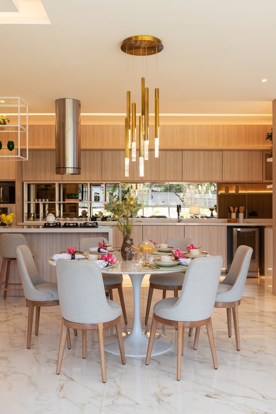Comedor moderno con mesa redonda y cocina integrada de madera — proyecto Decorados Vitória, por Pricila Dalzochio