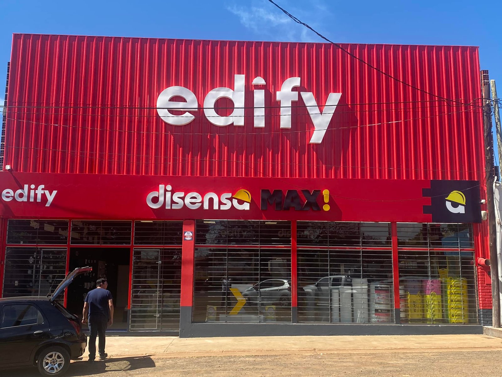 Fachada de local comercial con frente metálico rojo y cartel 'edify' — proyecto Edify Posadas, por Arquitecto Gustavo Maidana, en Posadas