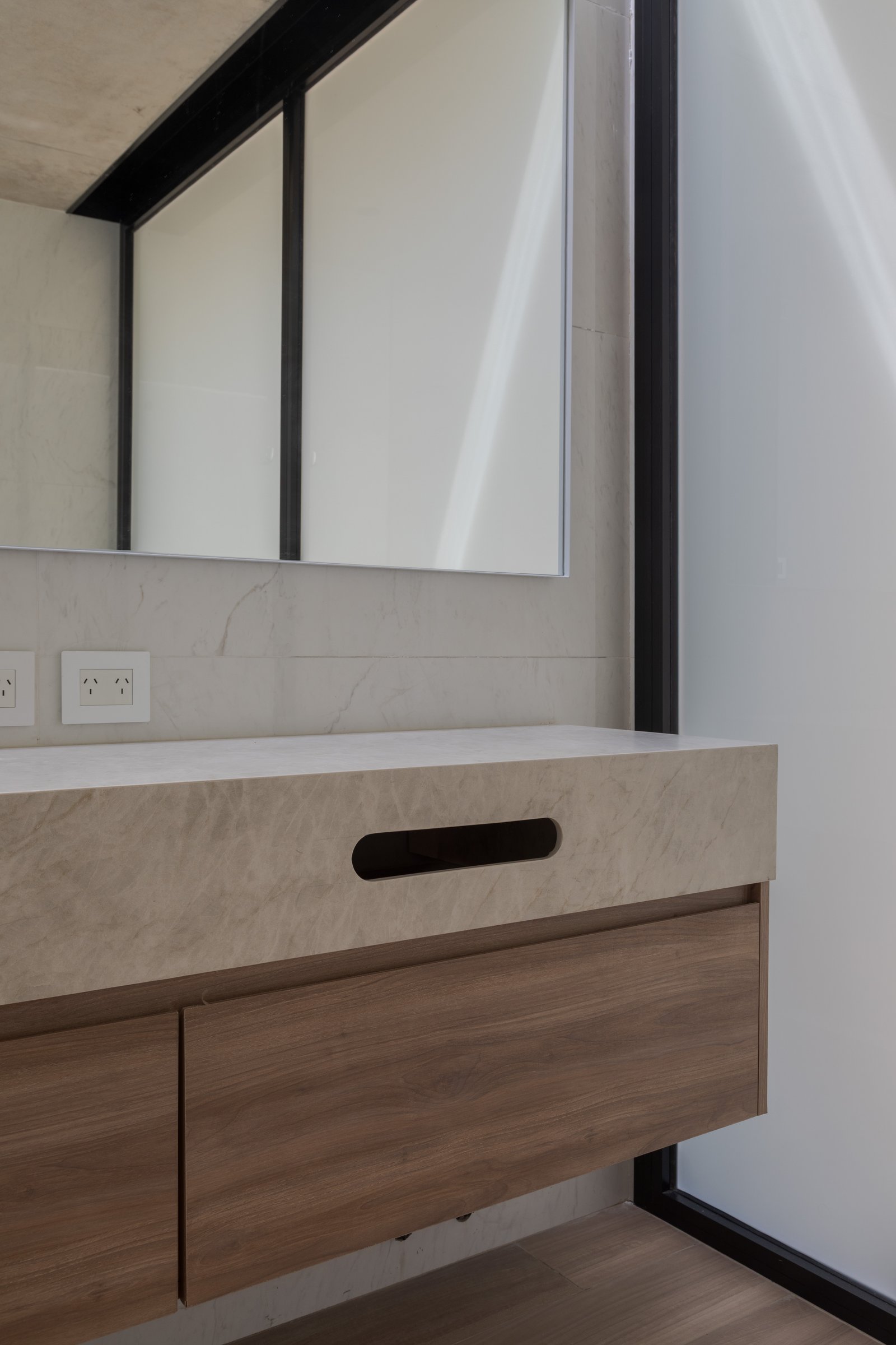 Baño moderno con vanitory de piedra beige y cajones de madera — proyecto Casa PLANALTO, por Grupo CRBN, en Av. Pres. Perón 10298