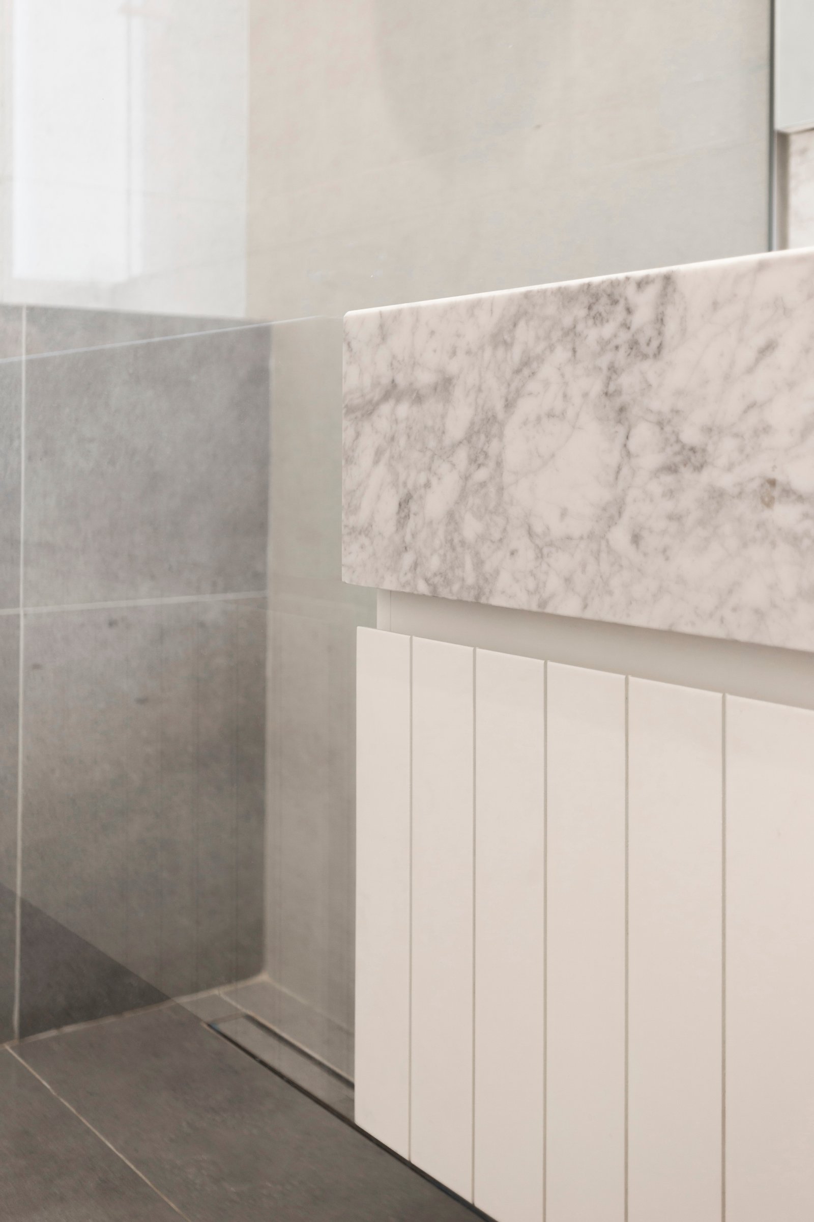 Baño moderno con revestimientos de piedra y mármol — proyecto Ayacucho, por JT ARQUITECTURA, en Buenos Aires