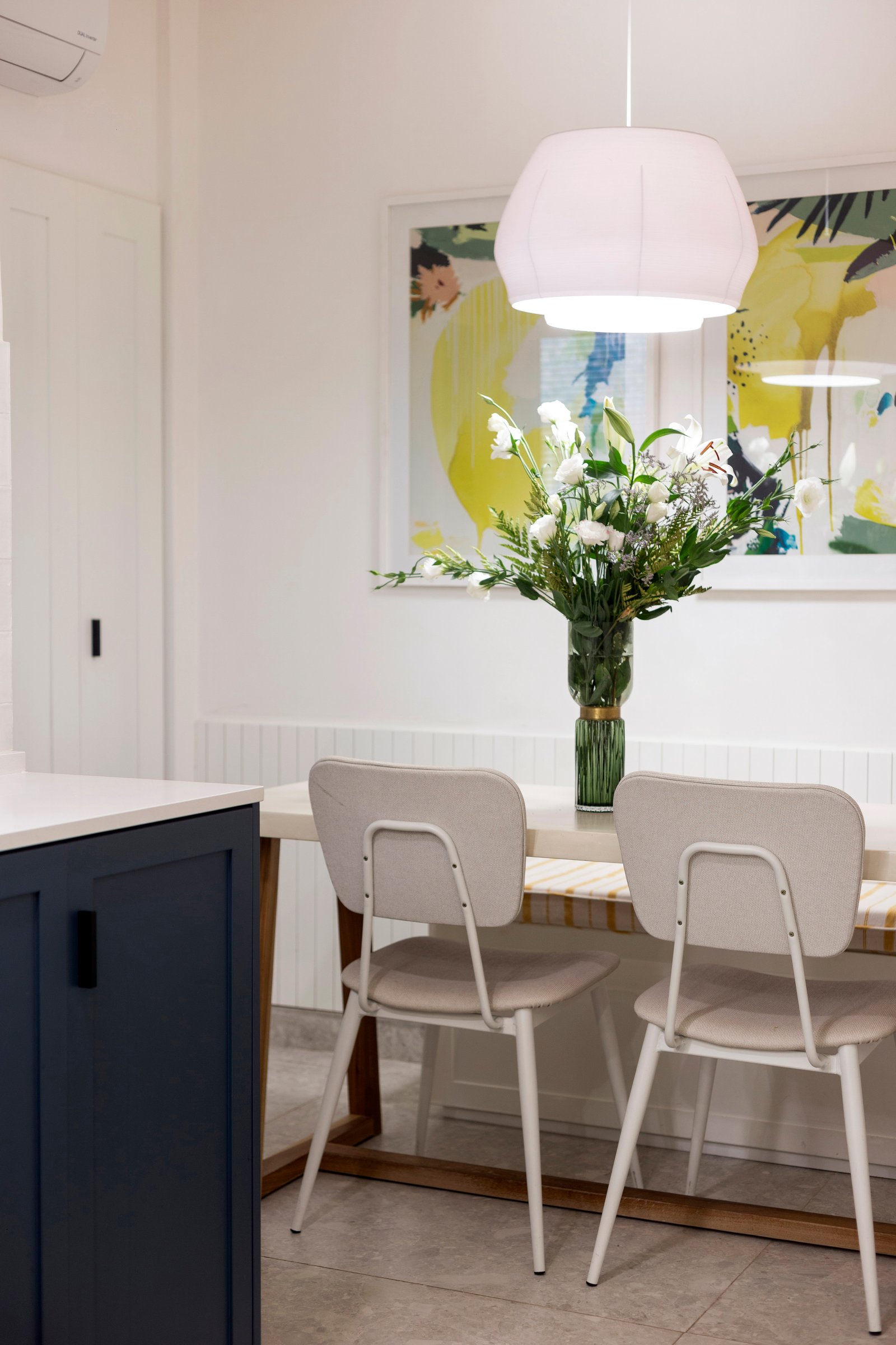 Comedor moderno con lámpara colgante geométrica y arte abstracto — proyecto Paraná, por JT ARQUITECTURA, en Buenos Aires