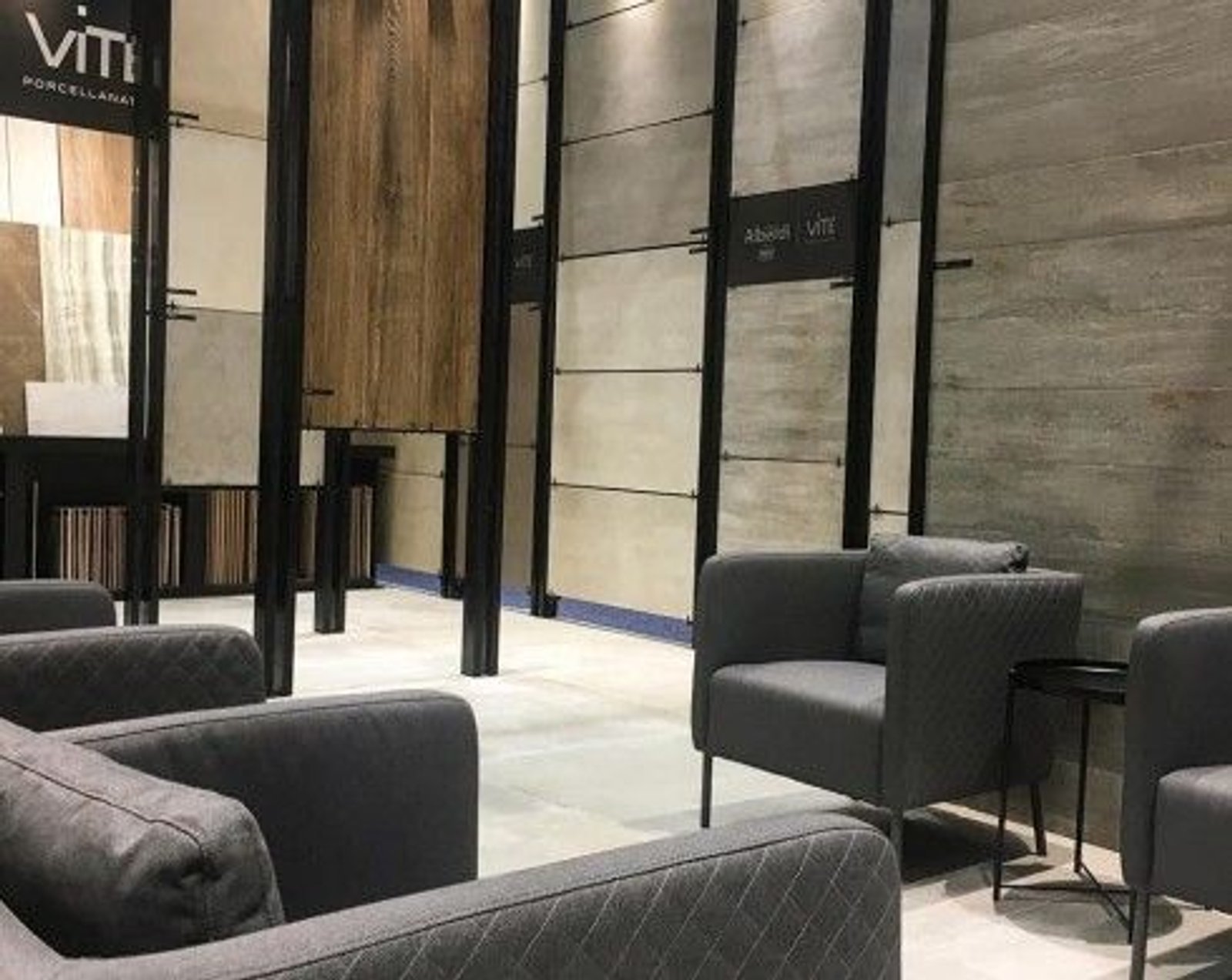 Sala de exposición de baldosas modernas con sillones grises — proyecto Coverings 2019, por Vite Porcellanato, en Orlando