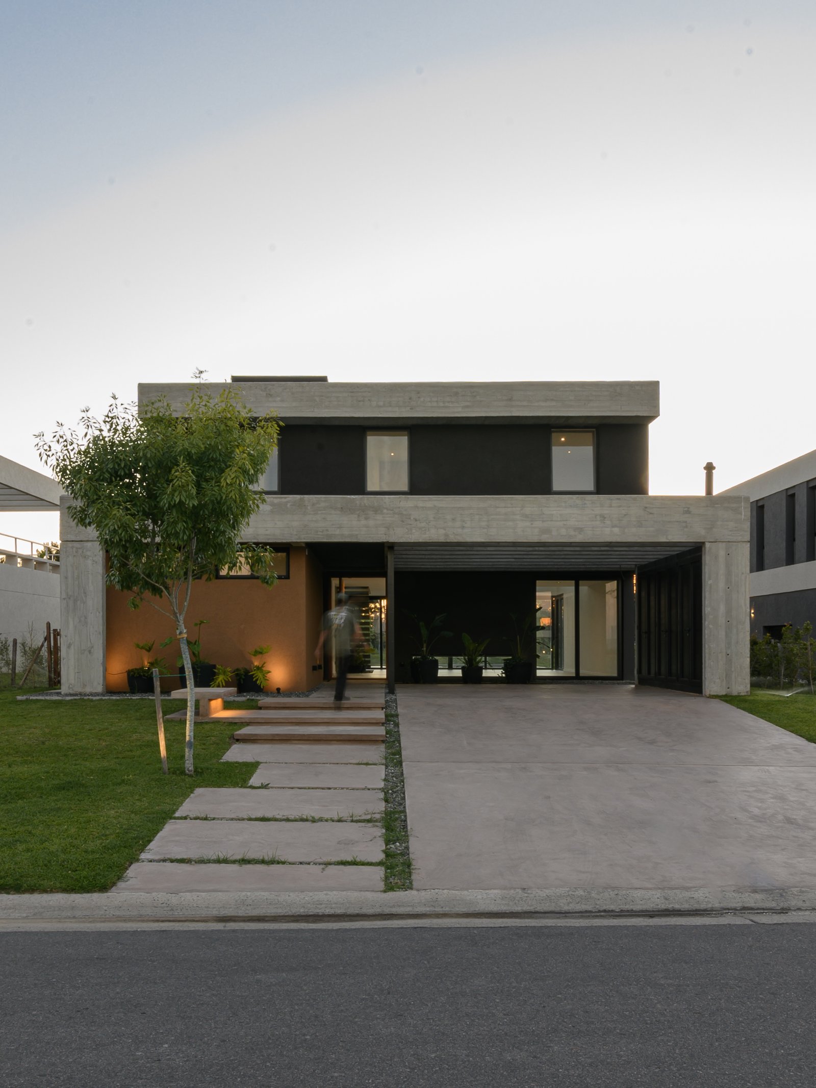 Casa moderna de hormigón visto con entrada cubierta y jardín — proyecto CASA CONCRETO, por Auge desarrollos & crowdfunding, en Nordelta