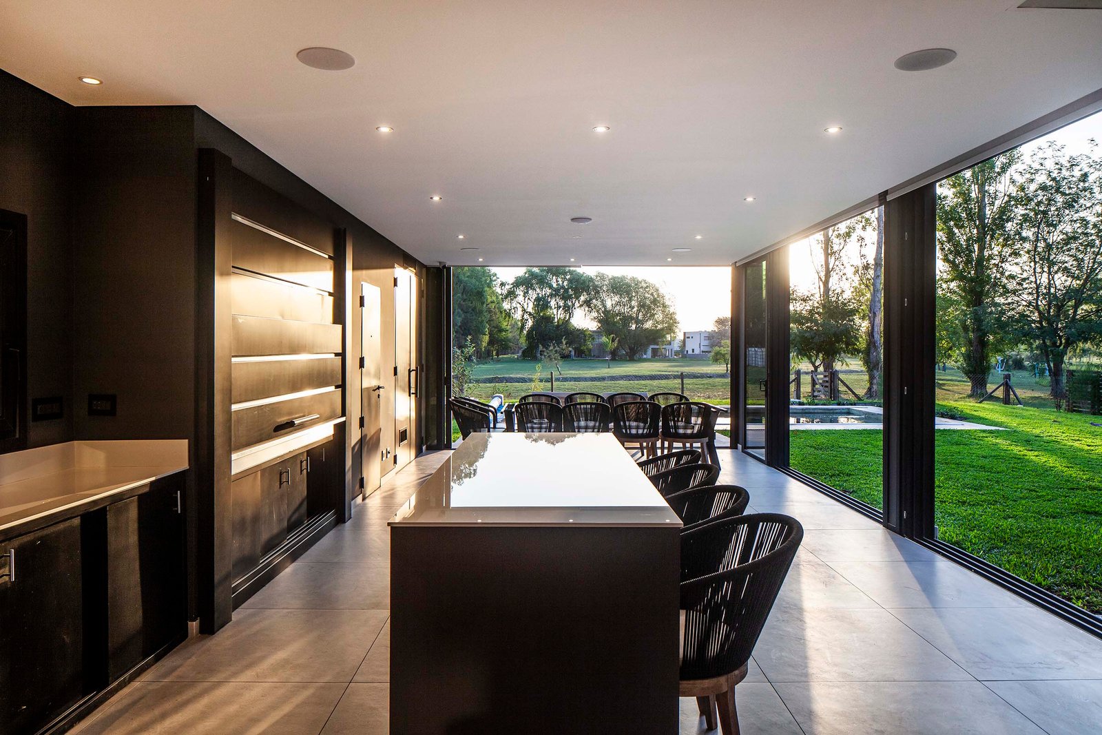 Comedor y cocina modernos con isla, vistas al campo — proyecto CASA T199, por A'PRIMA - Arquitectura Sustentable, en Los Robles 5901
