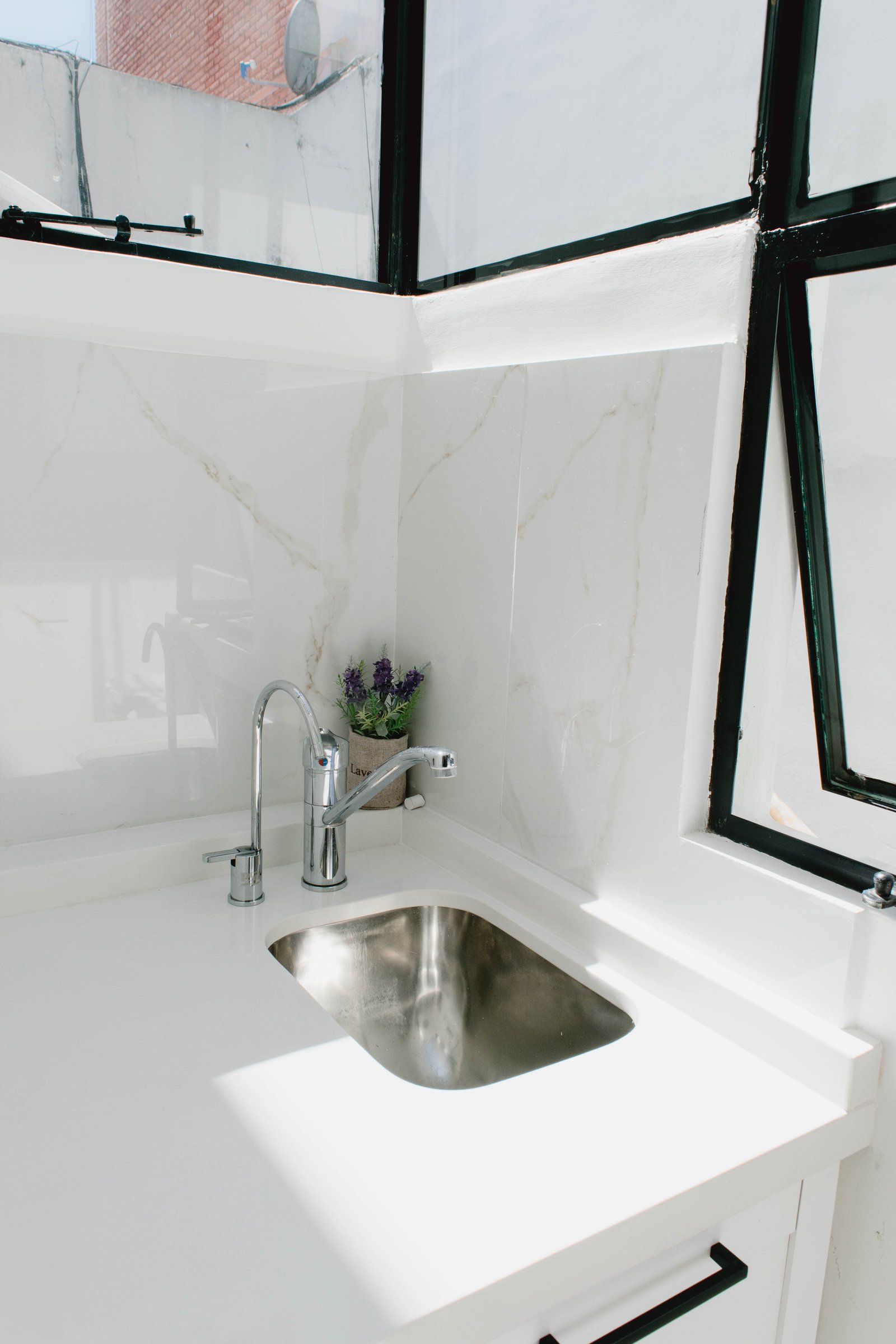 Cocina moderna con ventanales y pared de mármol — proyecto Goyena, por Martina Kleinert, en Caballito