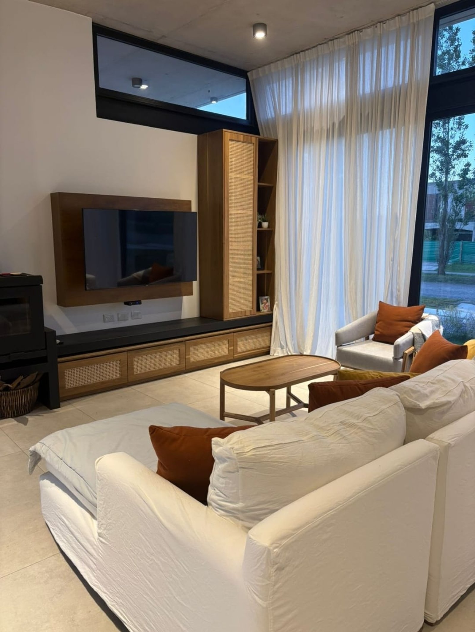 Living moderno con sofá blanco, mesa de madera y grandes ventanales — proyecto Proyecto San Roque - Diseño y ejecucion integral living , por MJS INTERIOR DESIGNER, en Luján