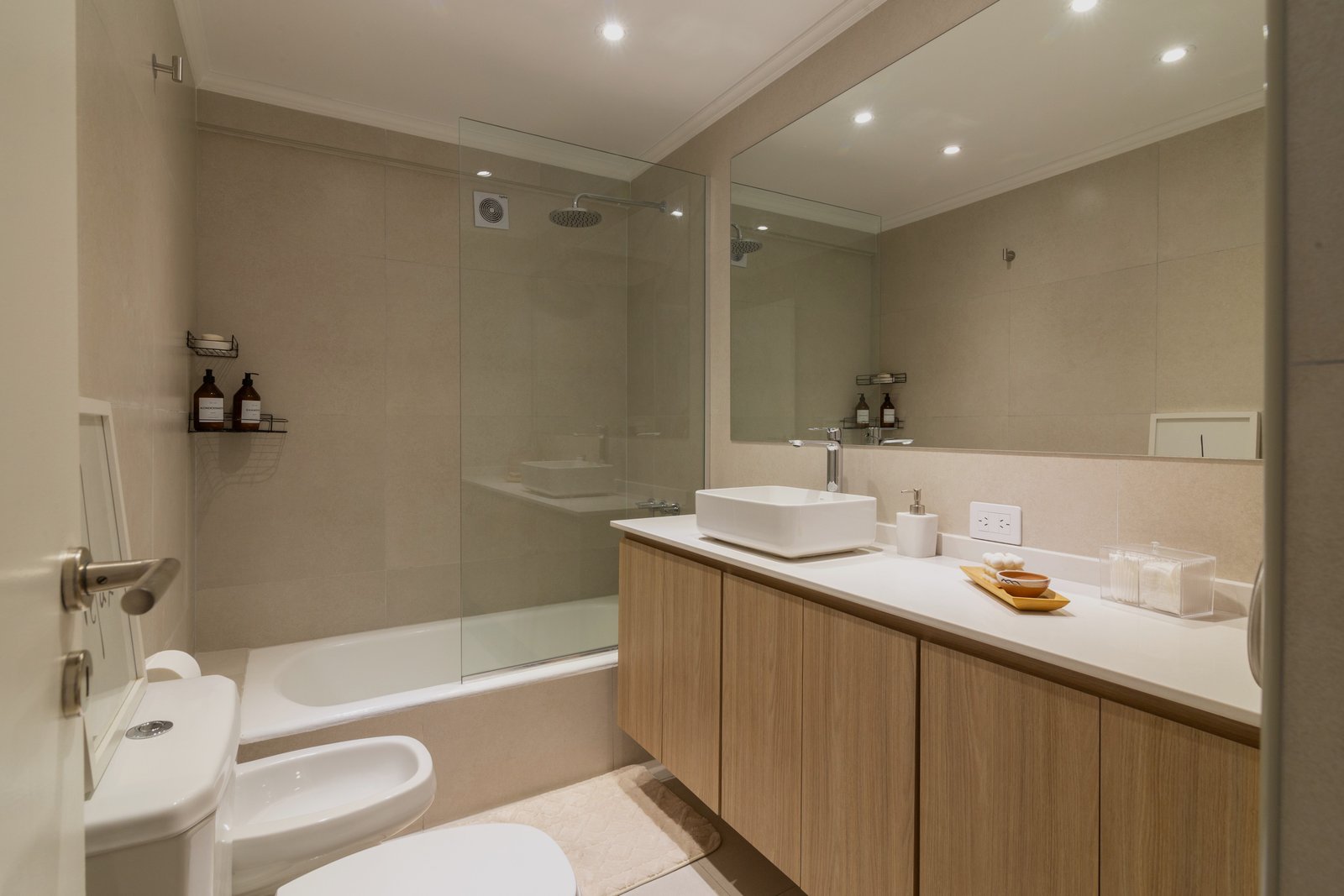 Baño moderno con acabados neutros, ducha y mueble de madera — proyecto Gascón, por Martina Kleinert, en Caballito