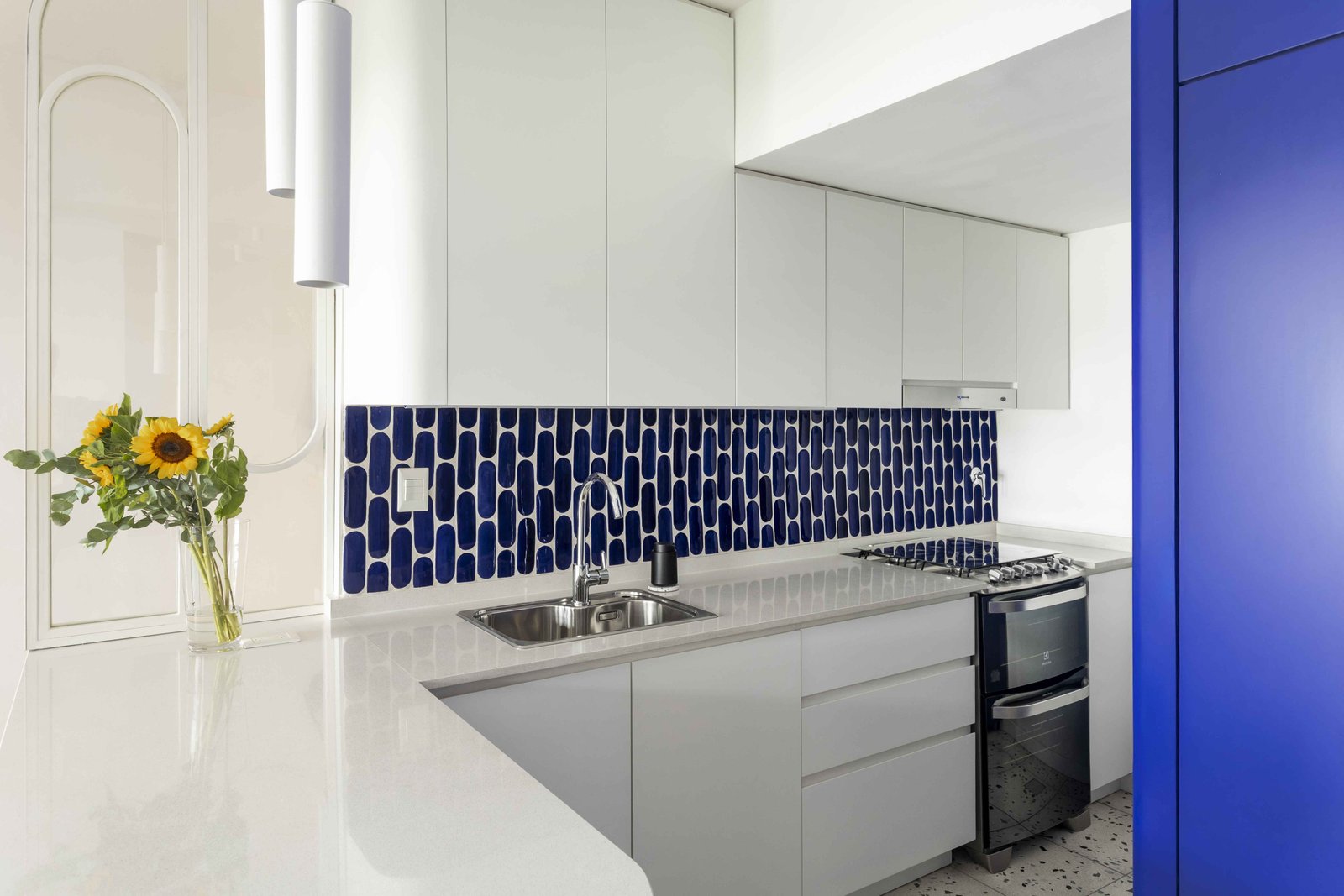 Cocina moderna con azulejos azules, encimera de mármol y girasol — proyecto Julián Alvarez, por Bouré Studio, en Palermo