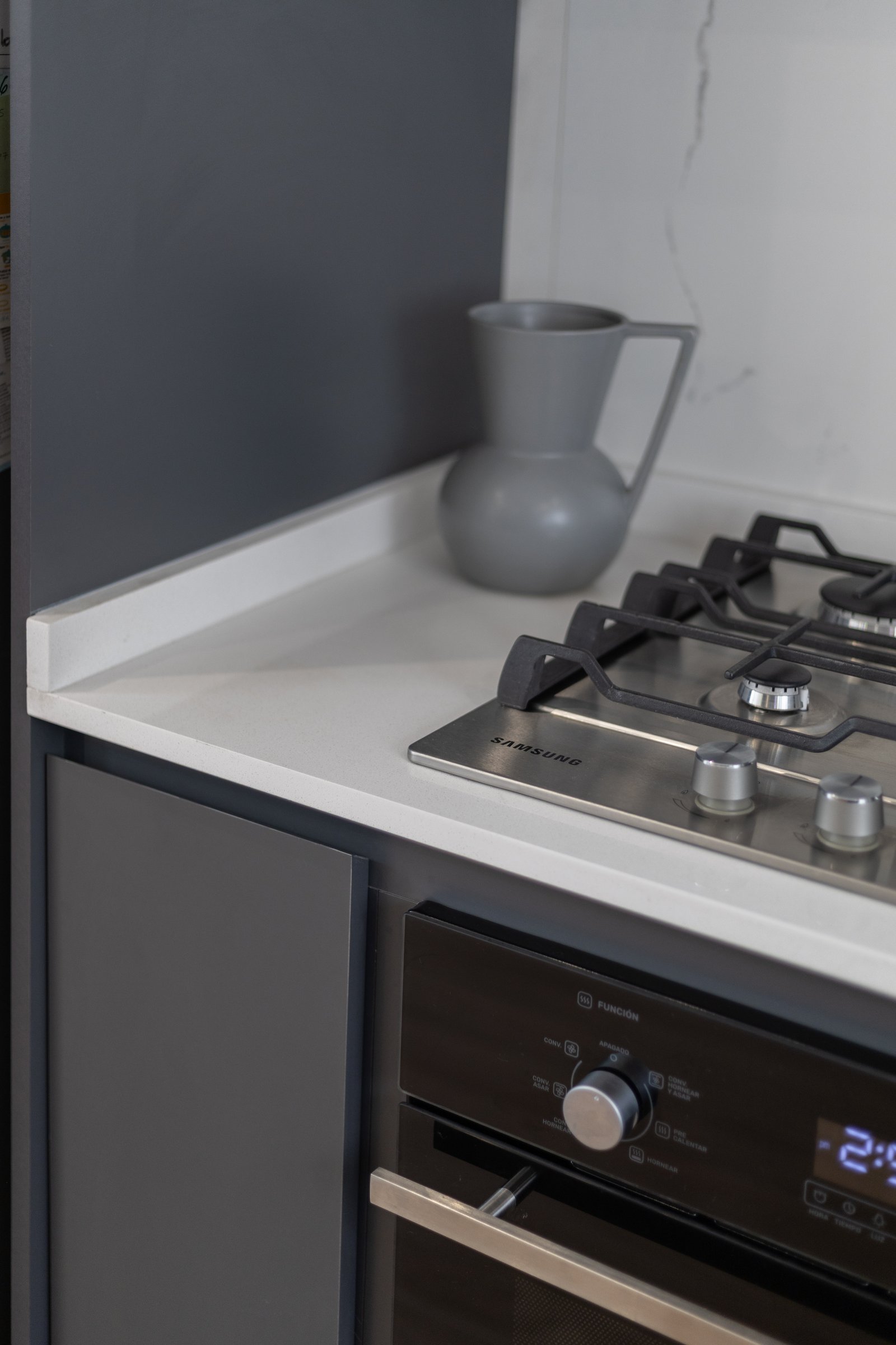 Cocina moderna con encimera blanca y electrodomésticos integrados — proyecto Boedo, por Martina Kleinert, en Boedo