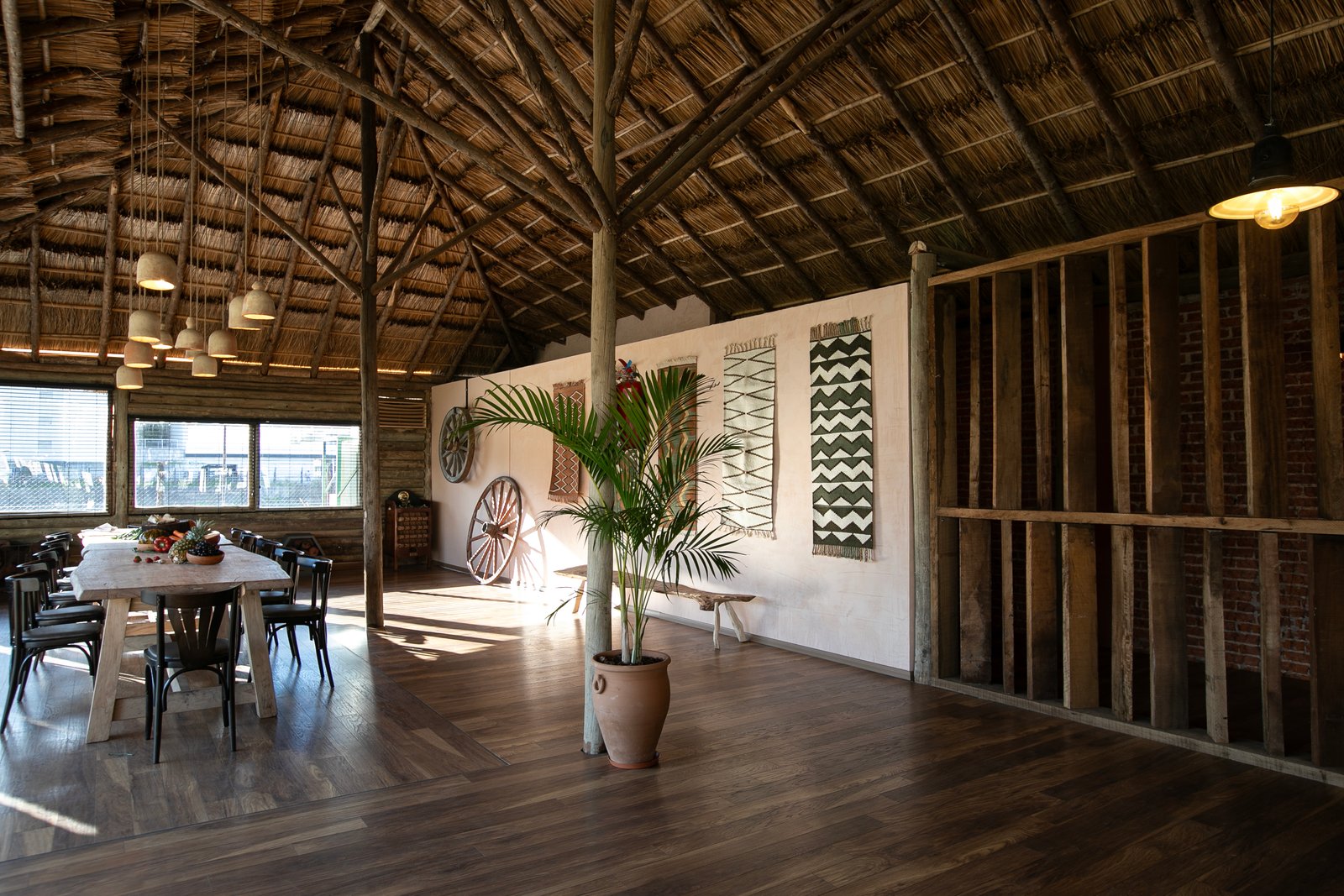 sala de jantar rústica com telhado de palha e móveis de madeira e vime — projeto Barreto, por Estudio Losa, em Palermo