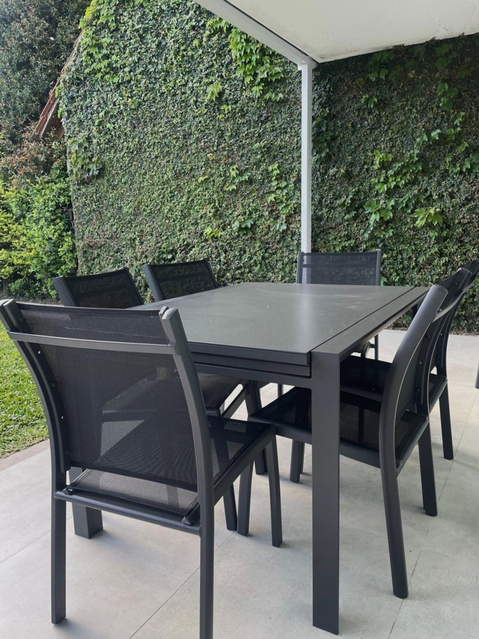 Sala de jantar externa moderna com parede verde e pergolado — projeto Comedor, por Casa Nuñez