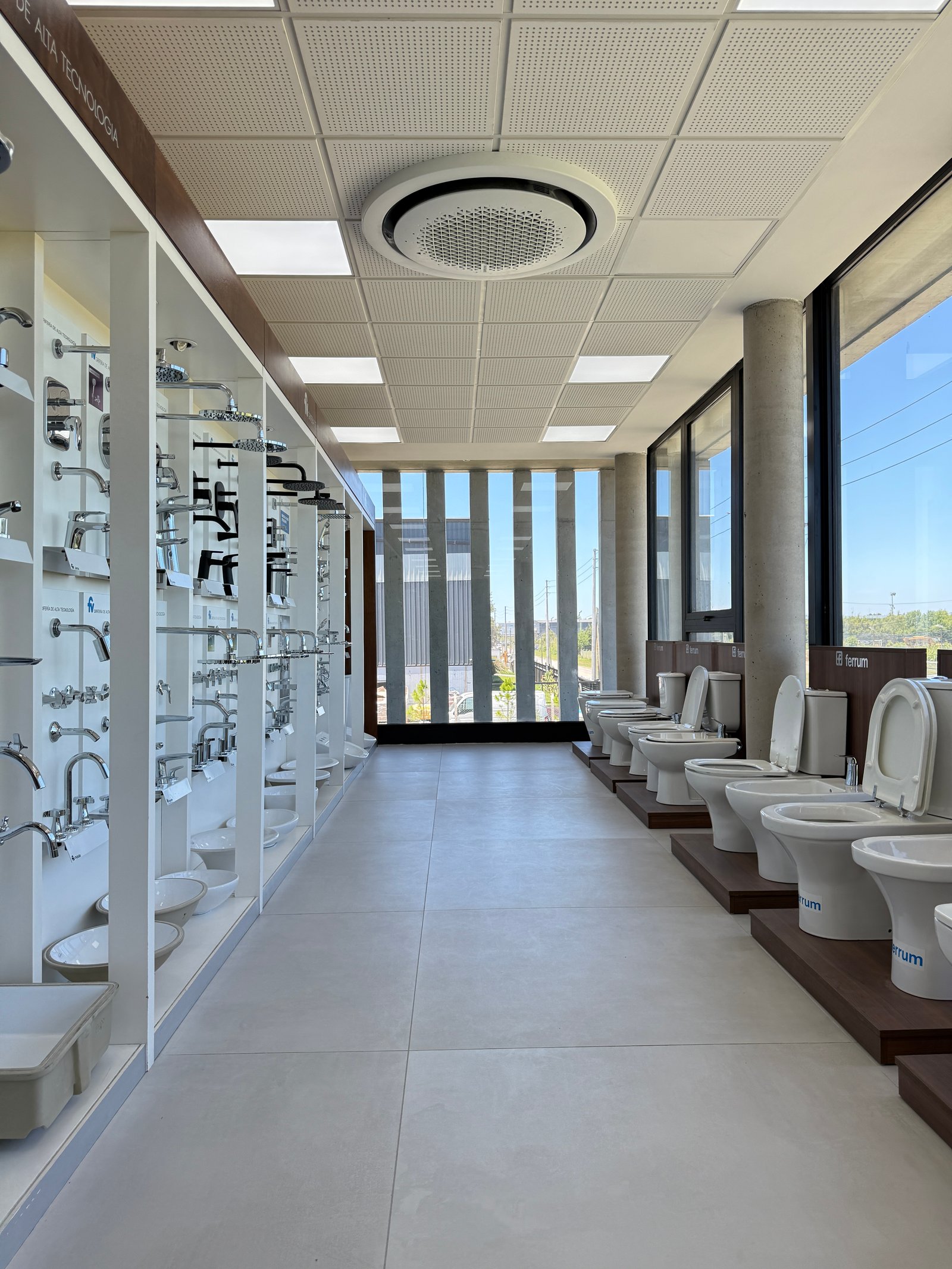 Showroom de sanitarios moderno con estanterías blancas y pisos grises — proyecto Showroom, por GAP HAUS, en Calle Austria Nte. 2450