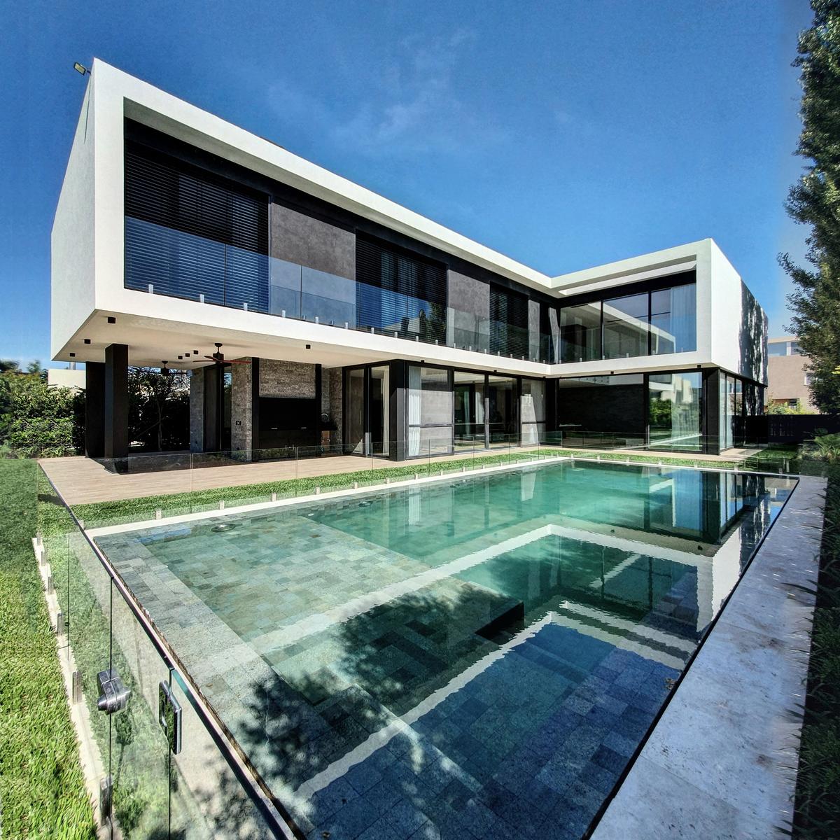 Casa moderna com piscina infinita e fachada contemporânea — projeto CASA WINDBELLS, por ABAD GADANO, em Tigre