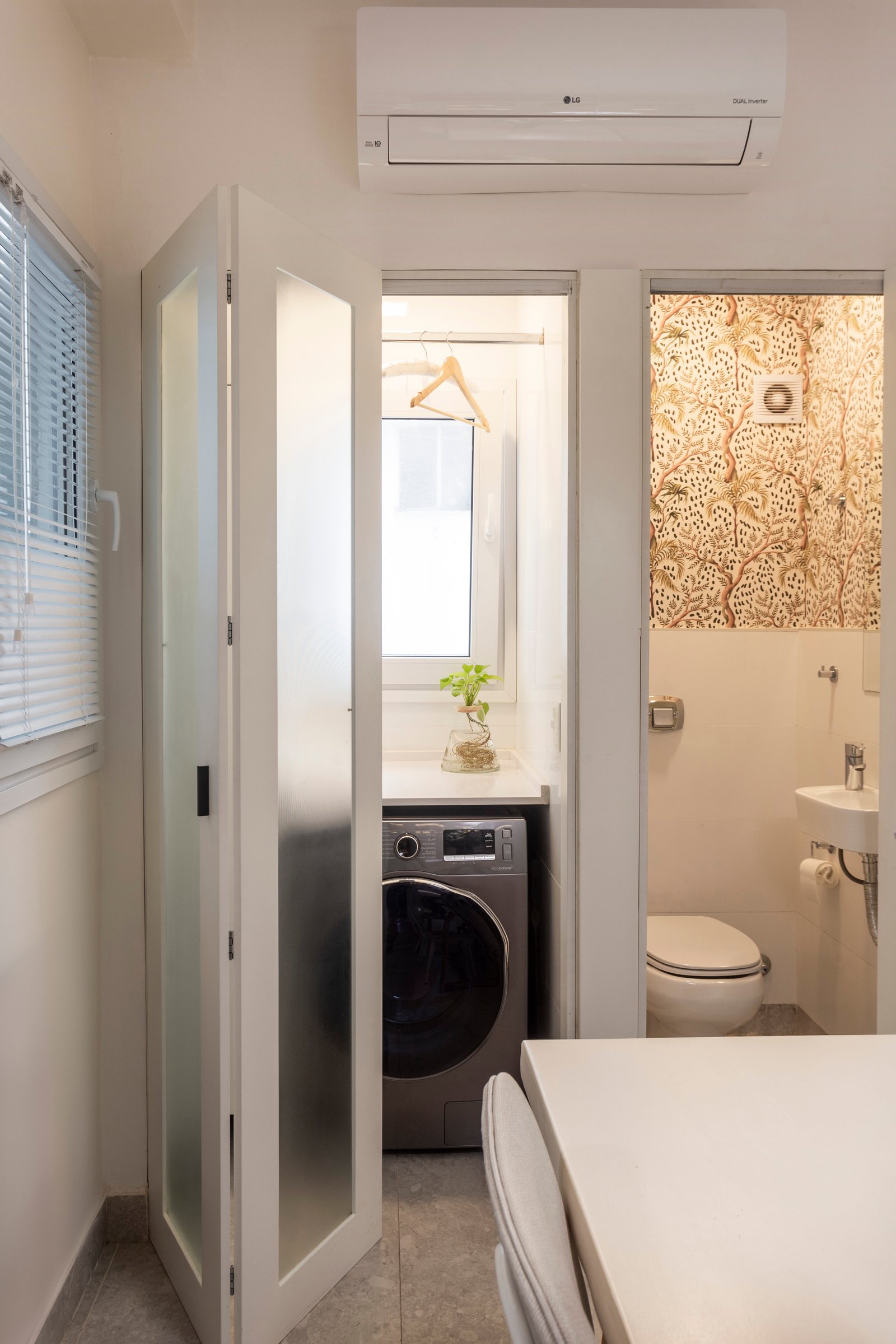 Lavadero y toilette integrado con puerta de vidrio esmerilado — proyecto Paraná, por JT ARQUITECTURA, en Buenos Aires