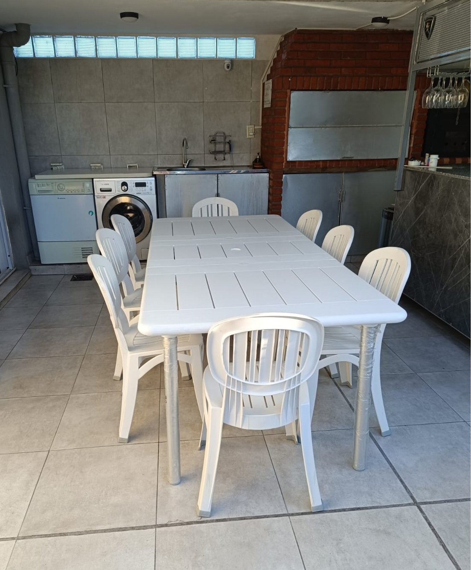 Comedor exterior con mesa y sillas de plástico blanco — proyecto Comedor, por Casa Nuñez