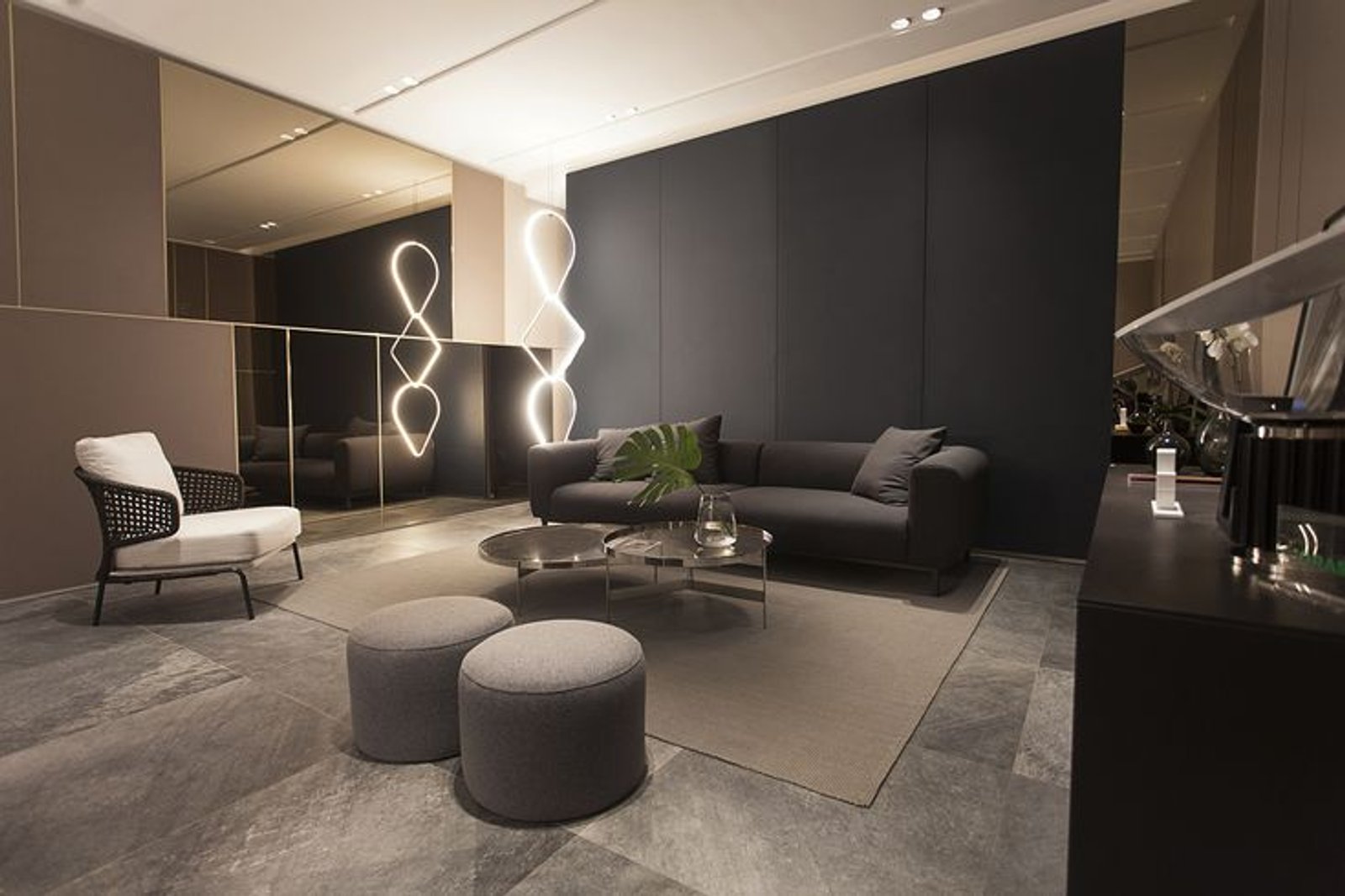Living moderno con sofá modular, iluminación escultural y paredes oscuras — proyecto Casa Foa Circulo Olivos 2019, por Vite Porcellanato, en La Lucila