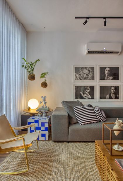 Living minimalista con sofa gris, plantas colgantes y arte en pared — proyecto Hugo Gloss, por Studio Ro-ca