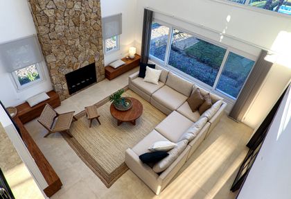 Living moderno de doble altura con pared de piedra y grandes ventanales — proyecto TRL 431, por Estudio Arq Daniel Tarrio