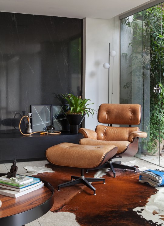 Sillón reclinable cuero frente ventanal con plantas colgantes — proyecto APARTAMENTO FL, por Frederico Bicalho Arquitetura