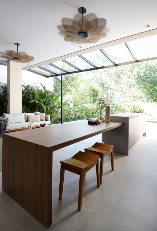 Cocina moderna con isla de madera, techo de vidrio y ventiladores loto — proyecto Projeto Destaque Club&Casa, por Barbara Dundes – Arquitetura + Design