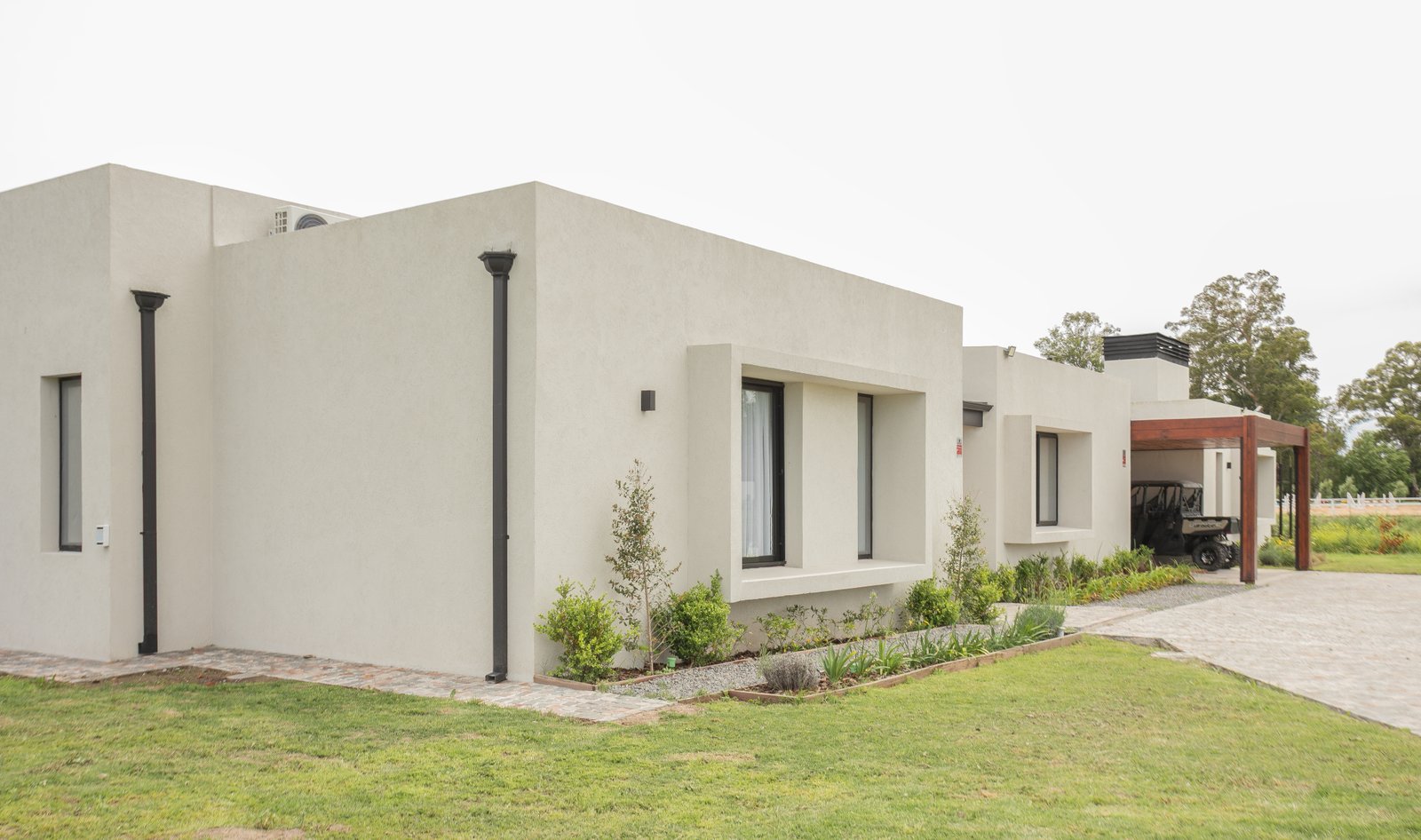 Casa moderna minimalista blanca con amplios ventanales y pérgola — proyecto CASA AB, por SEDE Arq., en Av. Pereda S/N