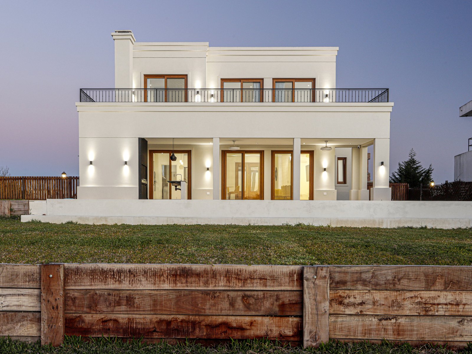 Casa moderna blanca de dos pisos con ventanales y patio — proyecto Casa SS182, por EZ architects, en M3CV+6H
