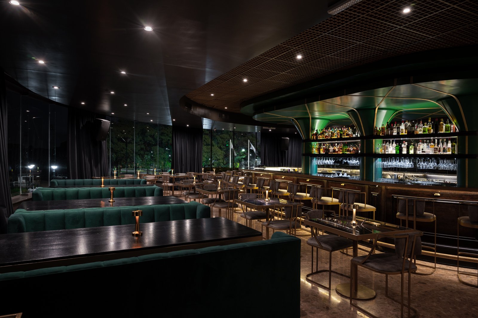 Interior de bar moderno con iluminación tenue y asientos verdes — proyecto PRESIDENTE BAR HIPODROMO, por AB ARQUITECTURA, en San Isidro