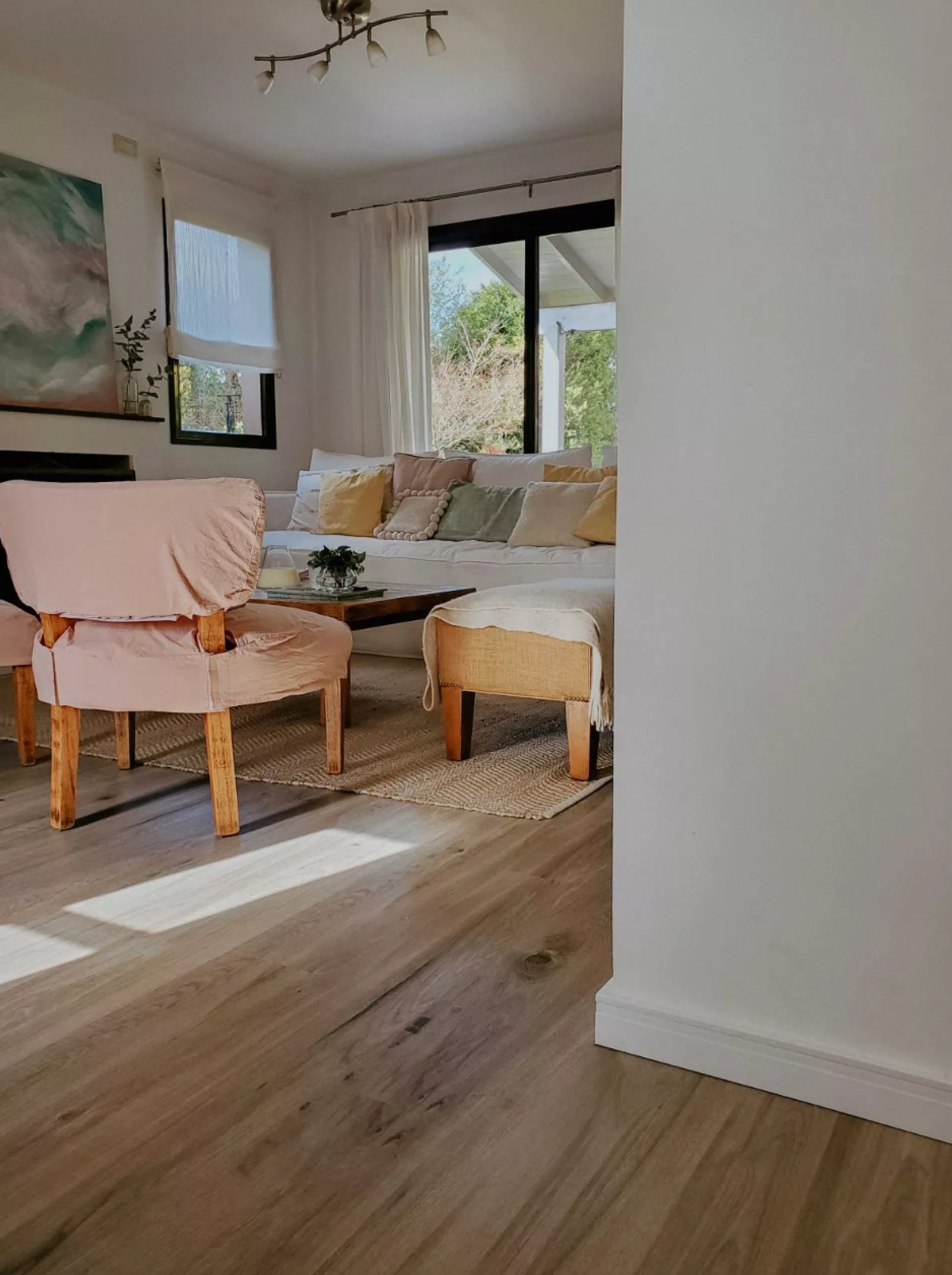 Sala de estar escandinava com toques boho e poltrona rosa — projeto Vanguardia y Distinción en el diseño interior., por ATRIM GLOBAL, em Buenos Aires