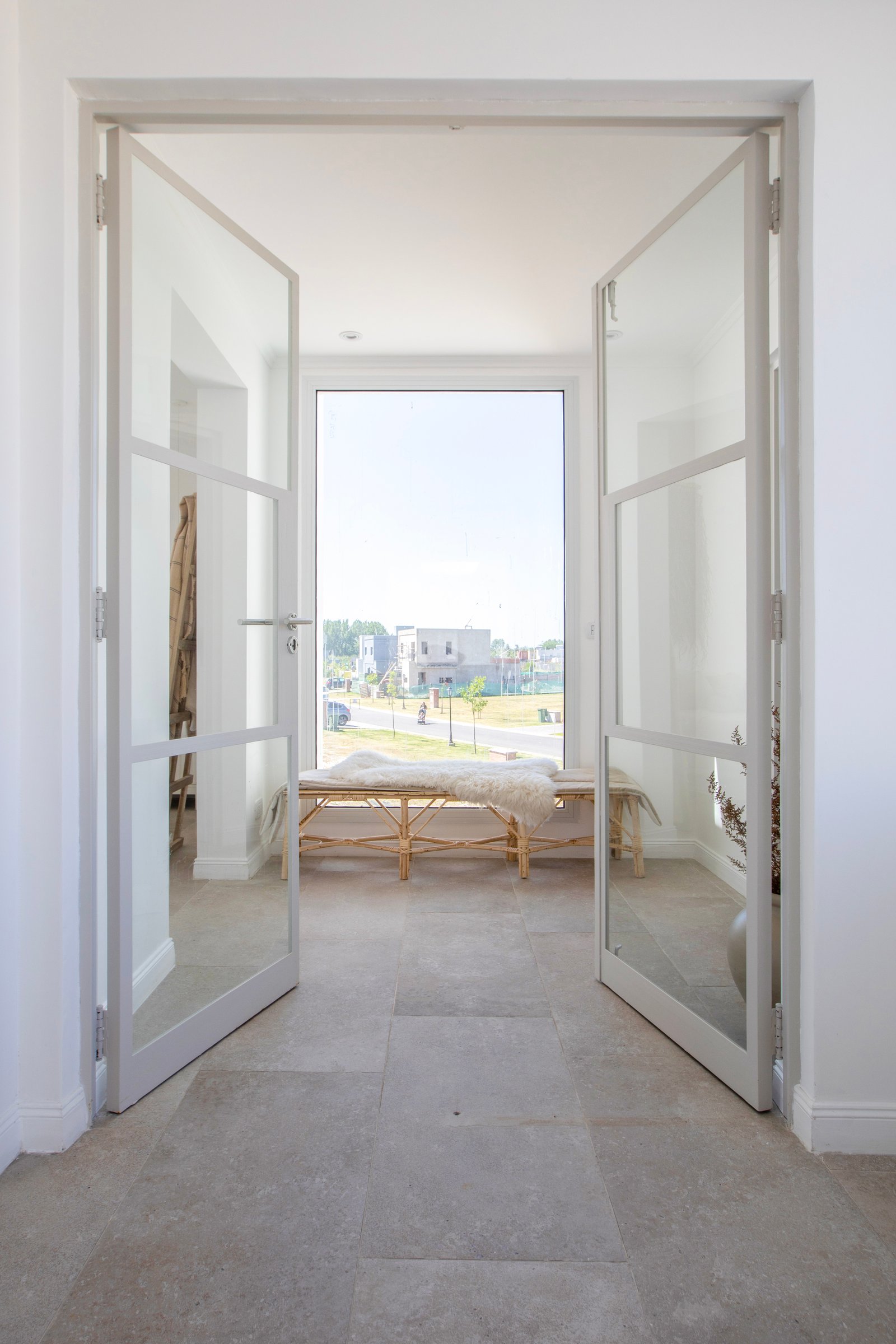 Pasillo moderno con puertas de vidrio y suelo de piedra — proyecto OBRA LE PIETRE DEL CASALE SABBIA, por ILVA, en Provincia de Buenos Aires