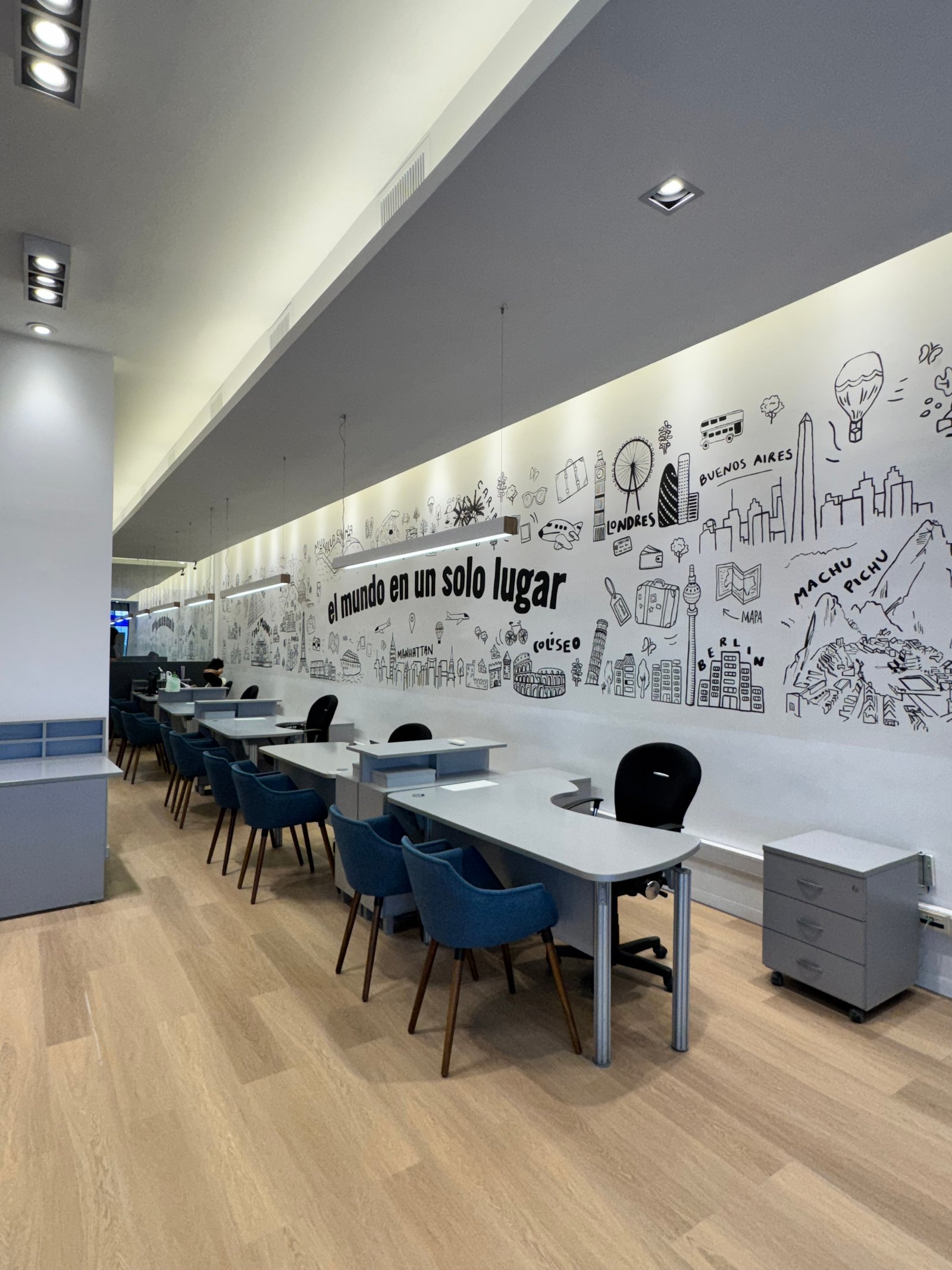 Escritório moderno com mural gráfico mundial e mesas curvas — projeto Pezzati viajes, por Remodela tu local, em Buenos Aires