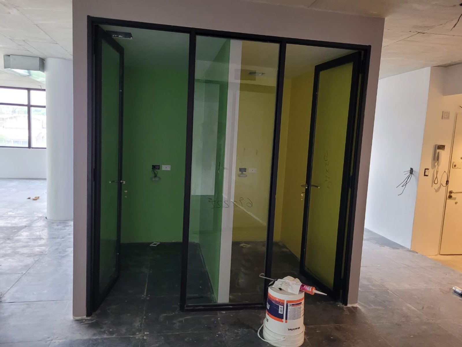 pasillo de obra con paredes verdes y divisiones de vidrio — proyecto Cerramientos en Bindex 4+4, por Cristalcenter, en Parque Patricios