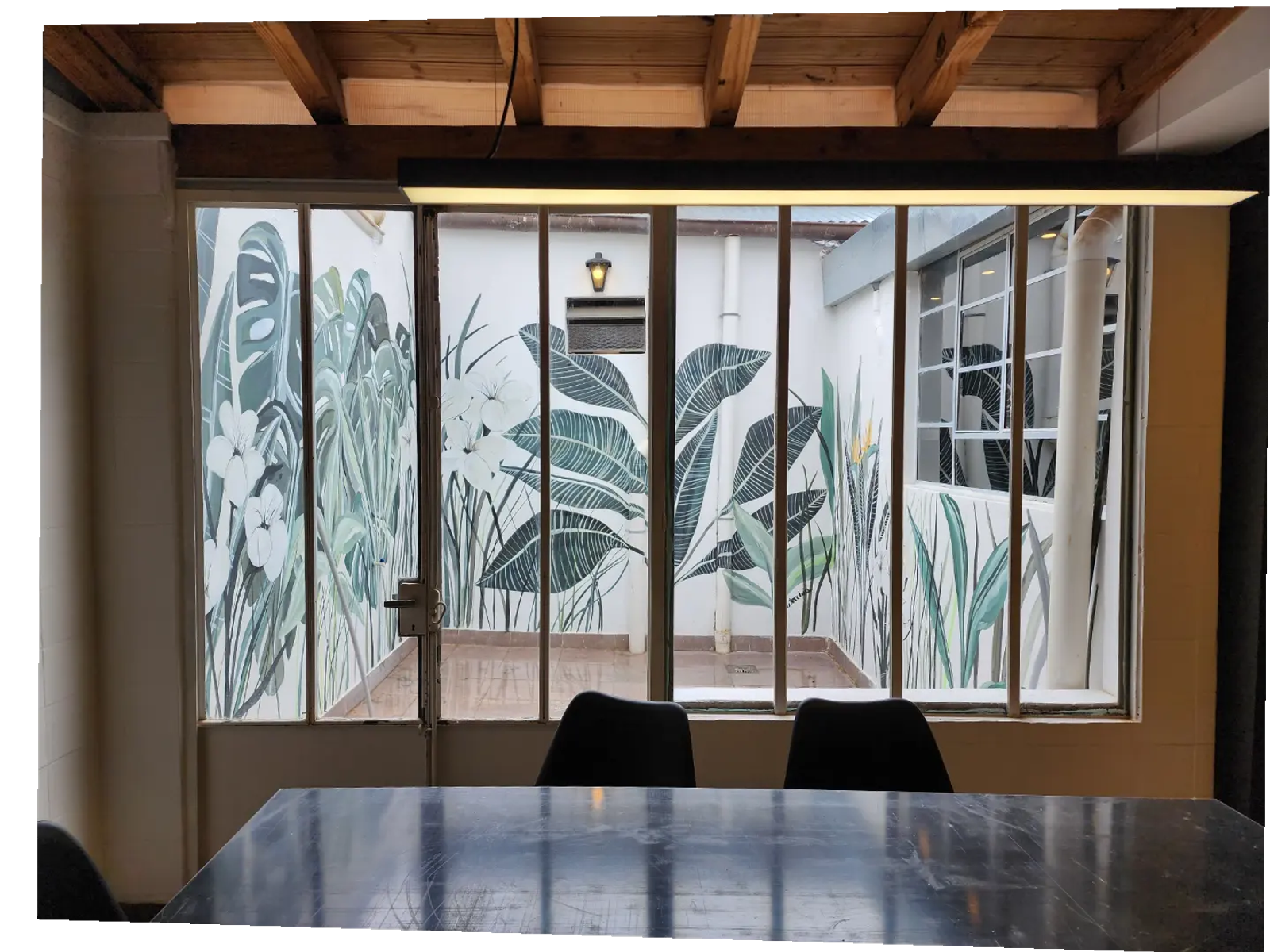Comedor con mural tropical y patio interior — proyecto Taller Pachamama, por Luciana González Anderson, en Salta