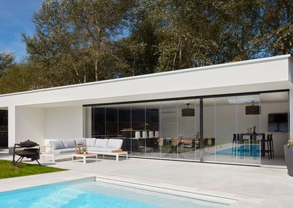 Casa moderna blanca con pileta, terraza y grandes ventanales — proyecto QUINCHO - PARRILLA , por CERRAMIENTOS PANORAMICOS, en Canning