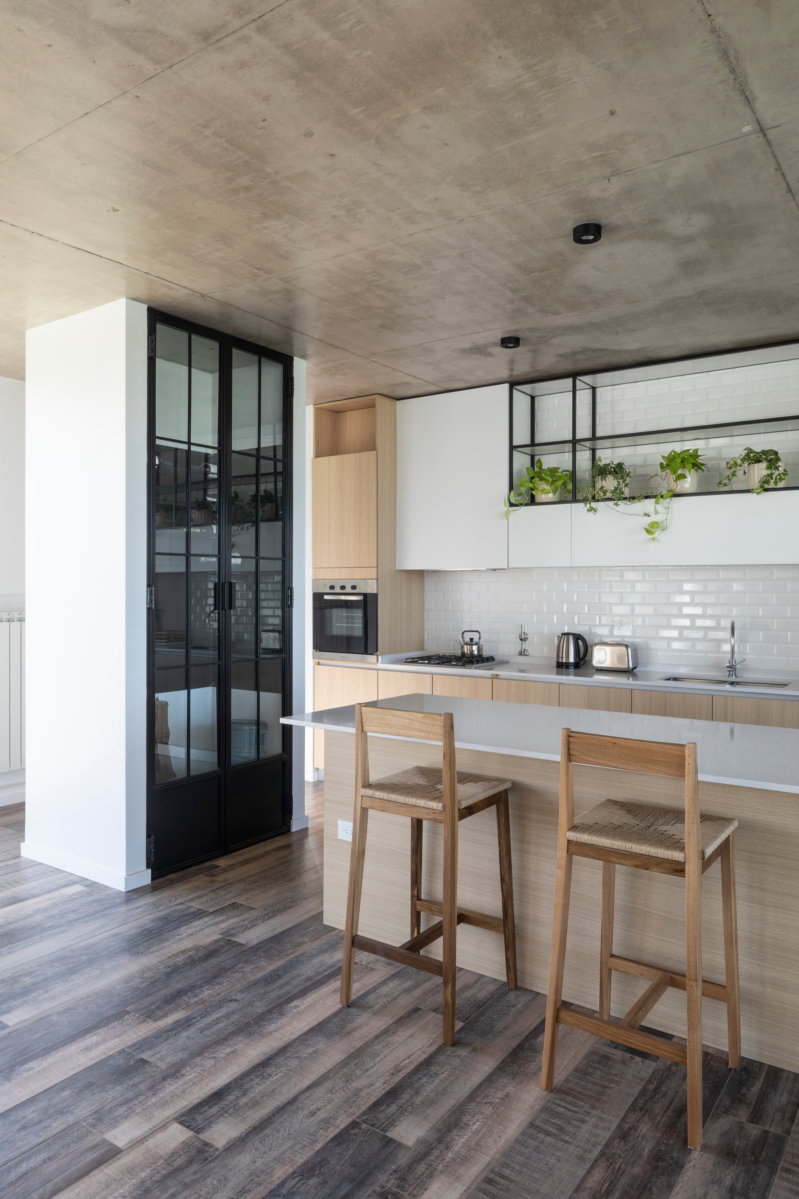 Cocina moderna industrial con isla, techo de hormigón y piso de madera — proyecto Casa Cruz , por Grupo CRBN, en B2812 Exaltación de la Cruz