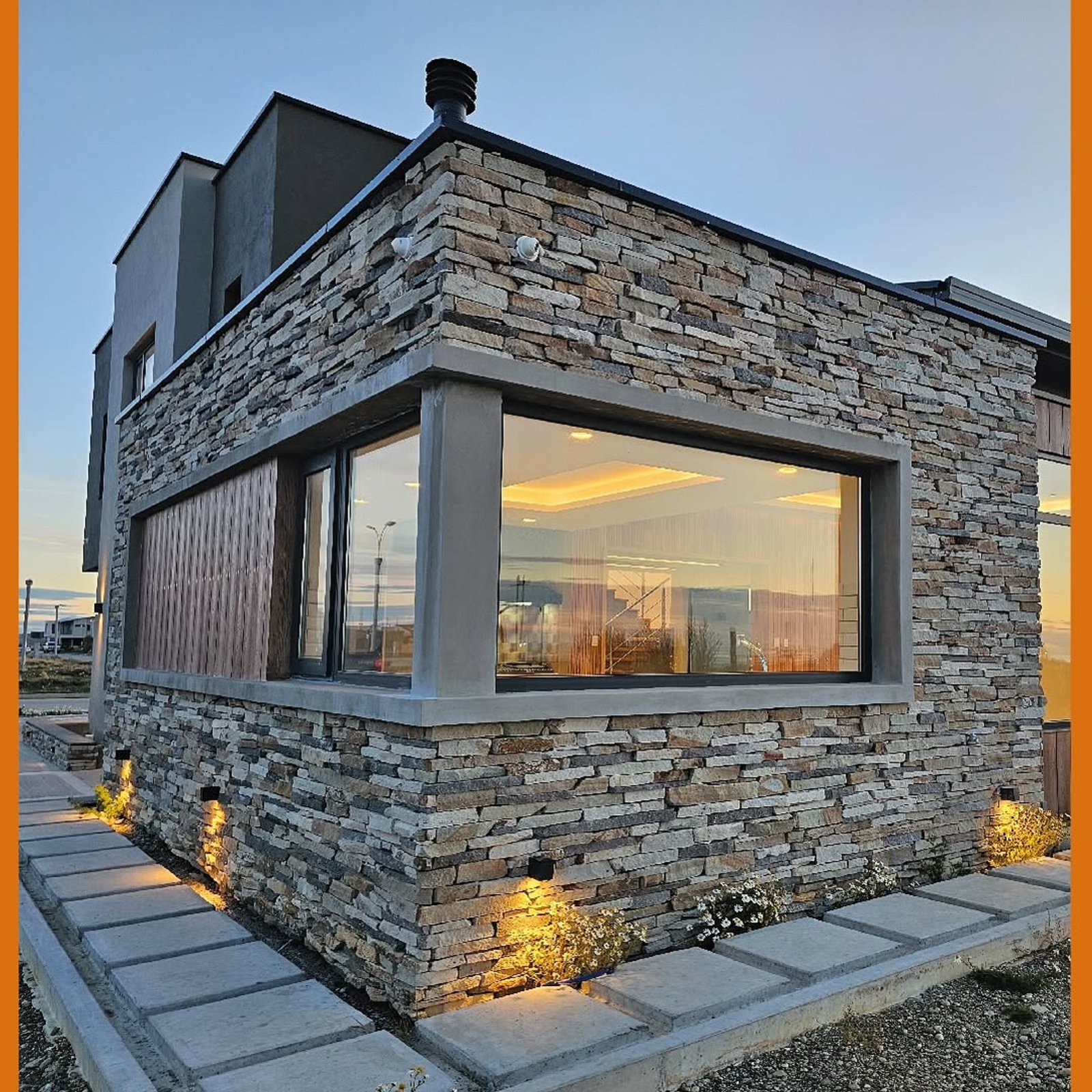 Fachada moderna con piedra y grandes ventanales — proyecto Casa Kren, por MUCHTEK, en Río Grande