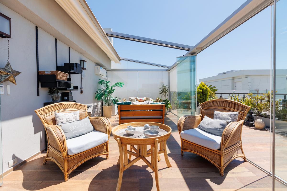 Terraço moderno com poltronas de vime e vista urbana — projeto TOLDER - PERGOLAS, por Argentina en Obra 2024, em Rincón de Milberg