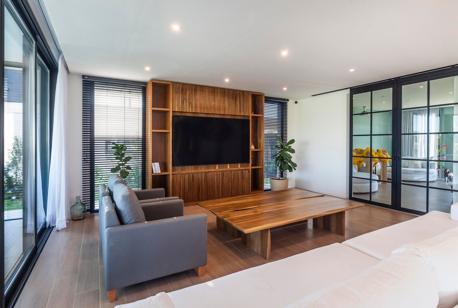 Sala de estar moderna com grandes janelas e detalhes em madeira — projeto CASA C313, por A'PRIMA - Arquitectura Sustentable, em Provincia de Buenos Aires