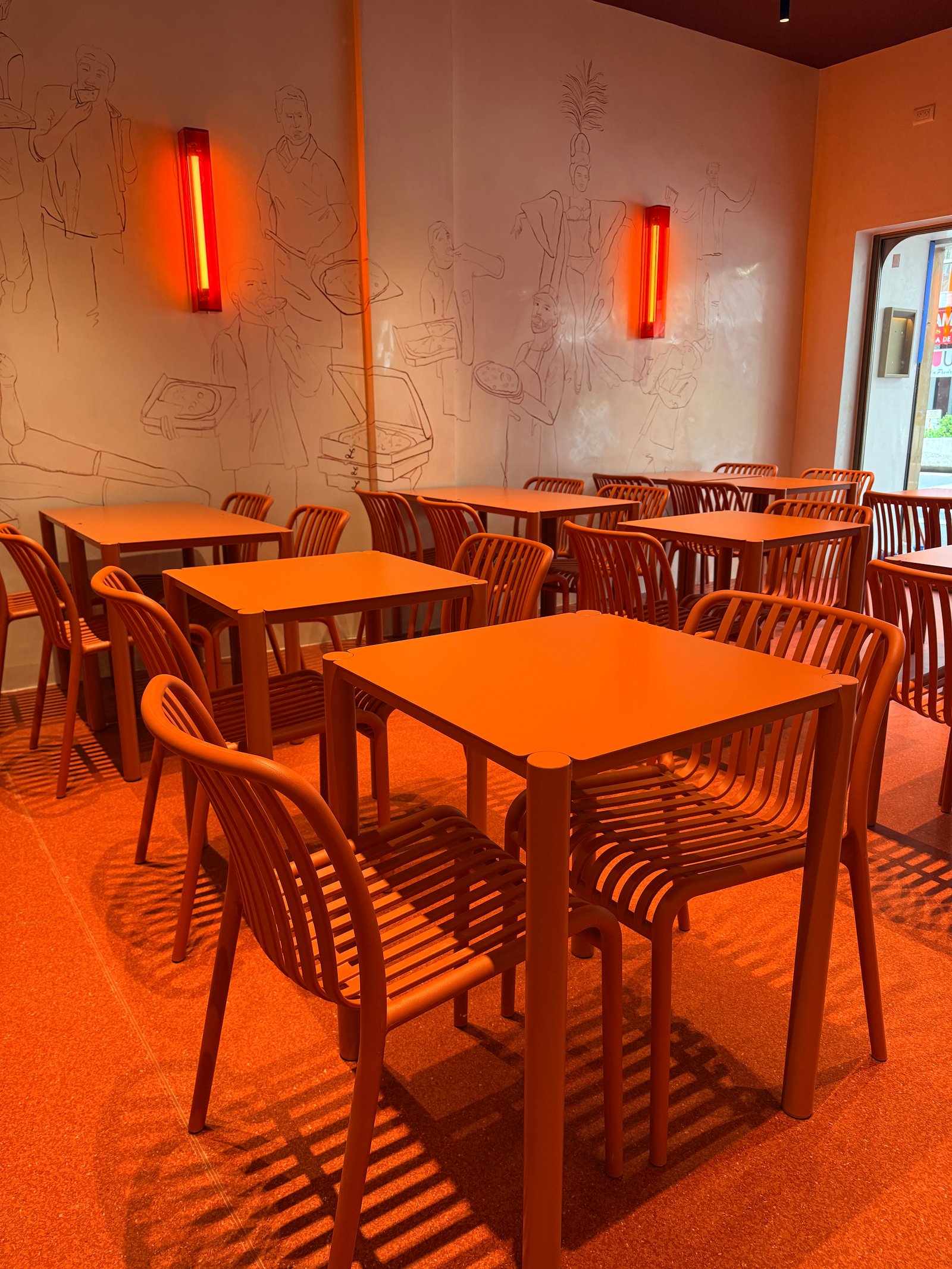 Sala de jantar laranja moderna com luzes lineares e mural — projeto Lunático, por Estudio Losa, em Av. Corrientes 1659
